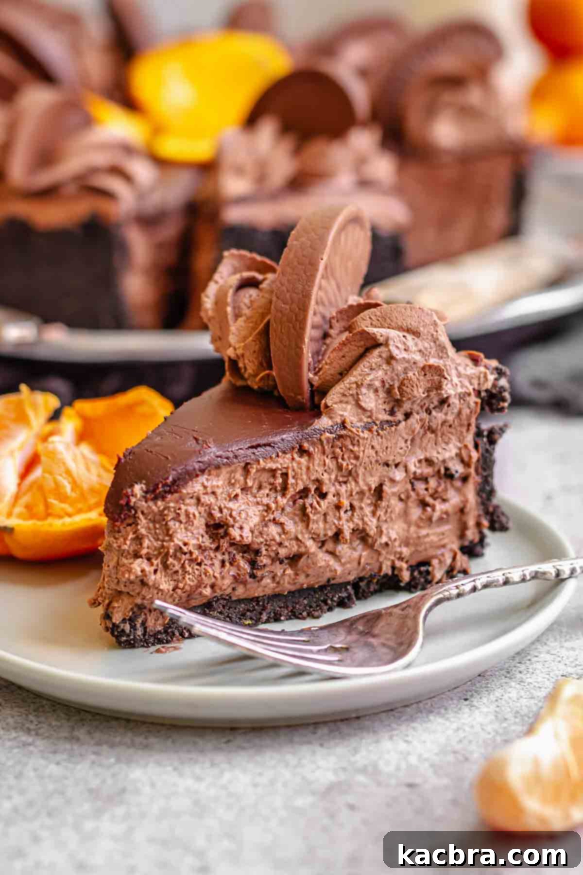 No-Bake Chocolate Orange Velvet Cheesecake 2 A slice of chocolate cheesecake on a plate with a fork next to i.