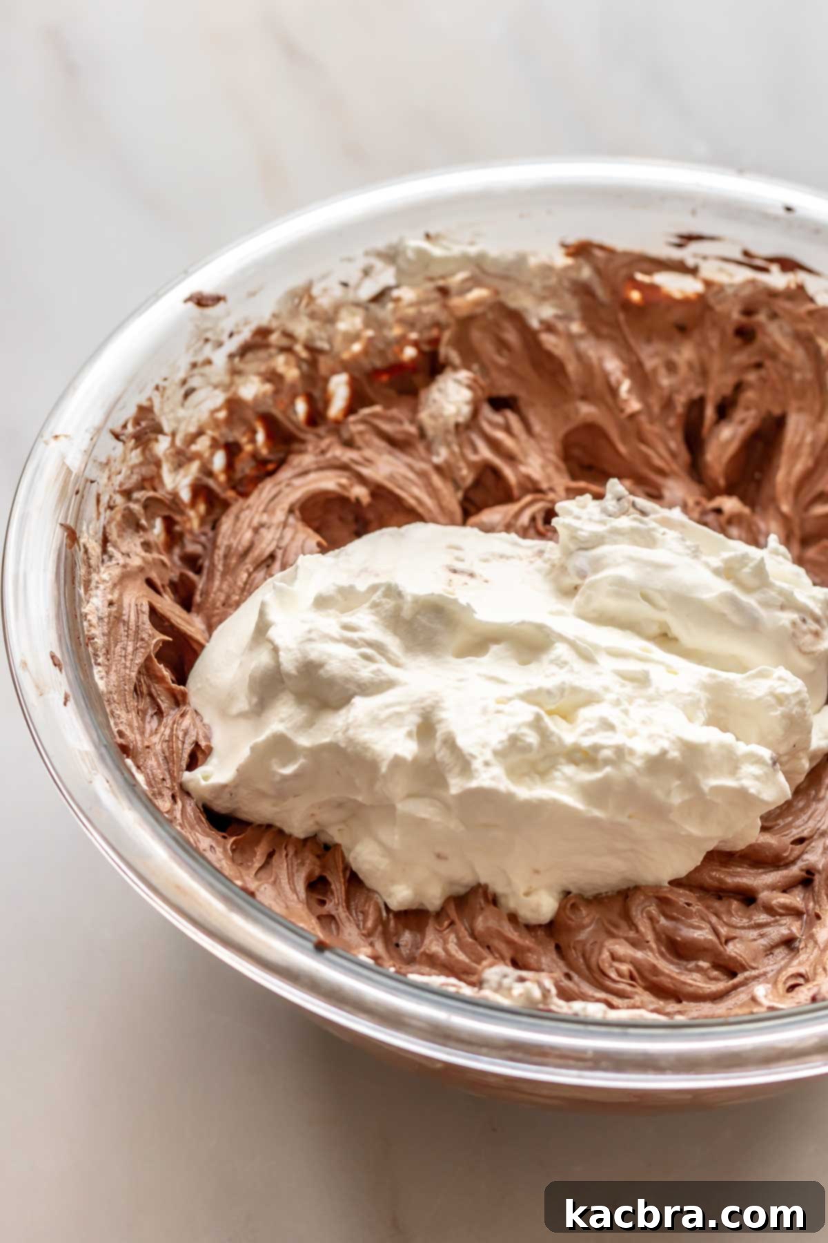 No-Bake Chocolate Orange Velvet Cheesecake 11 Whipped cream on top of chocolate cheesecake batter.