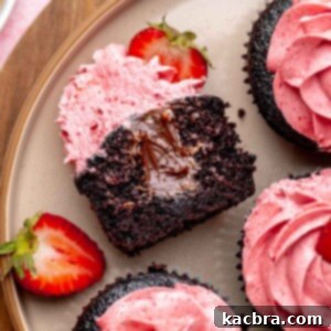 Chocolate strawberry cupcake cut open on a plate to show the chocolate filling.