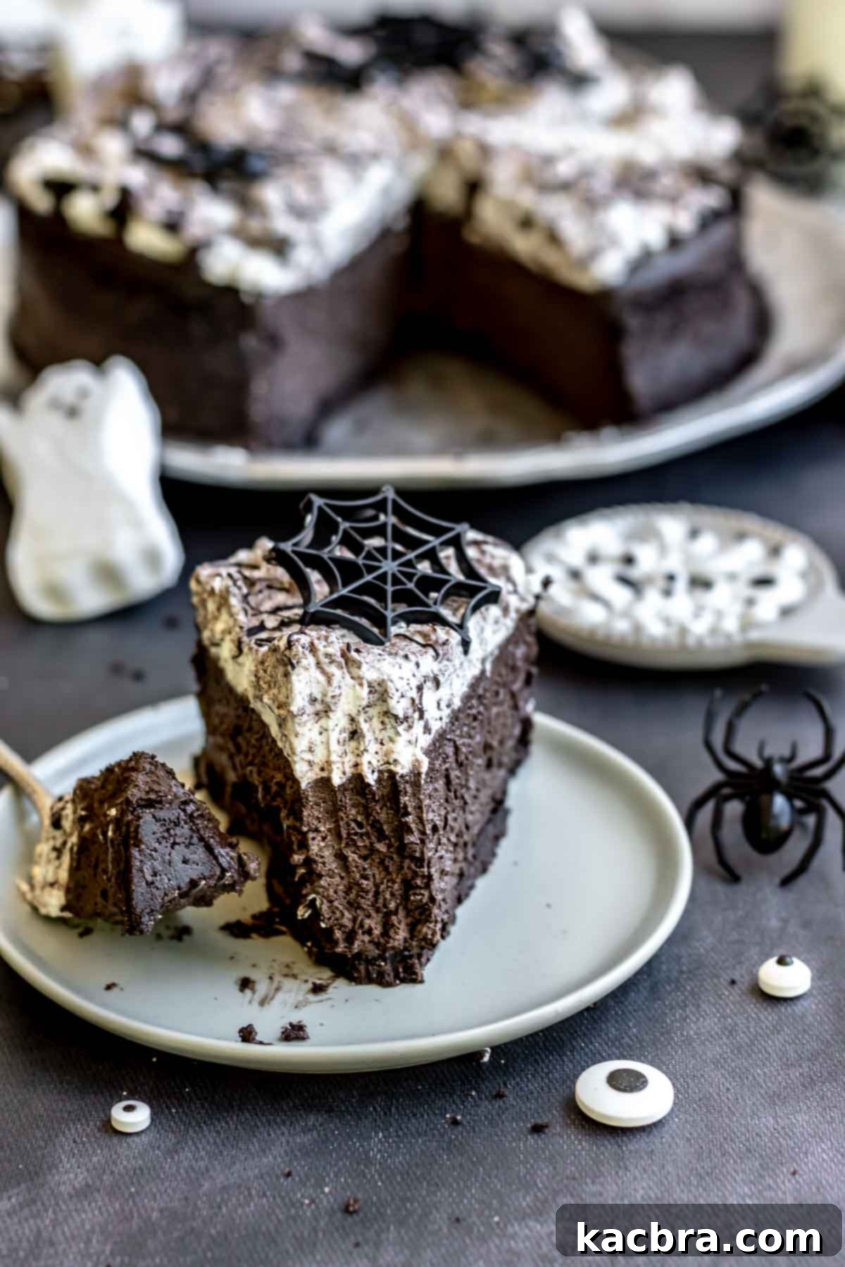 A slice of dark Halloween cheesecake on a plate with a fork having a bite removed, showcasing its rich texture.