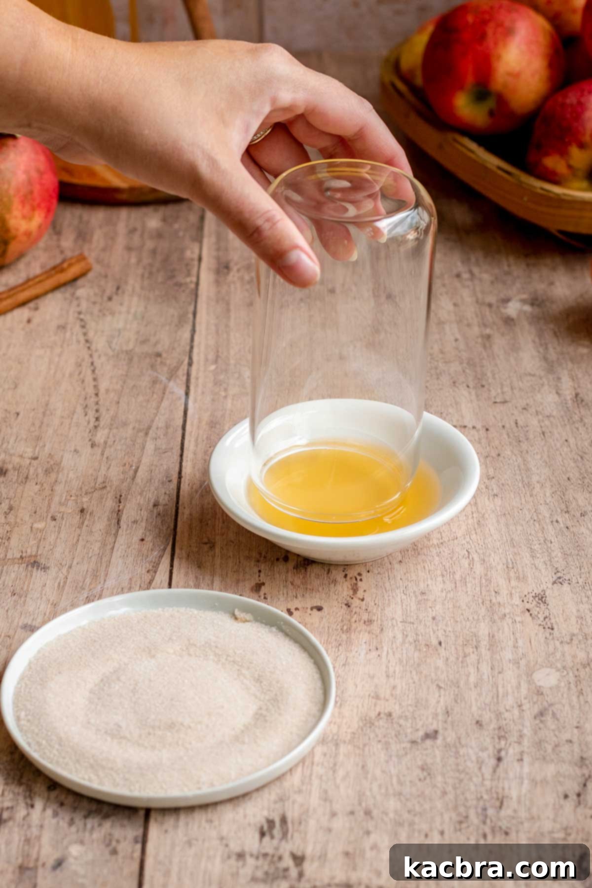Spiced Apple Slush: Customize Your Cool 5 A hand dips the rim of a glass off into apple cider.
