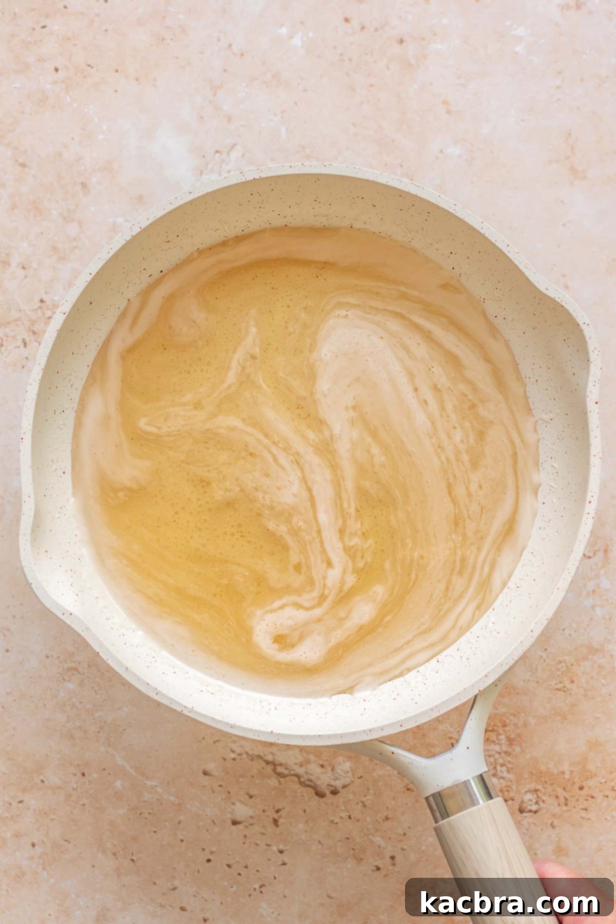 Golden Honey Baklava Dream Cake 17 Honey syrup bubbling in a small saucepan.