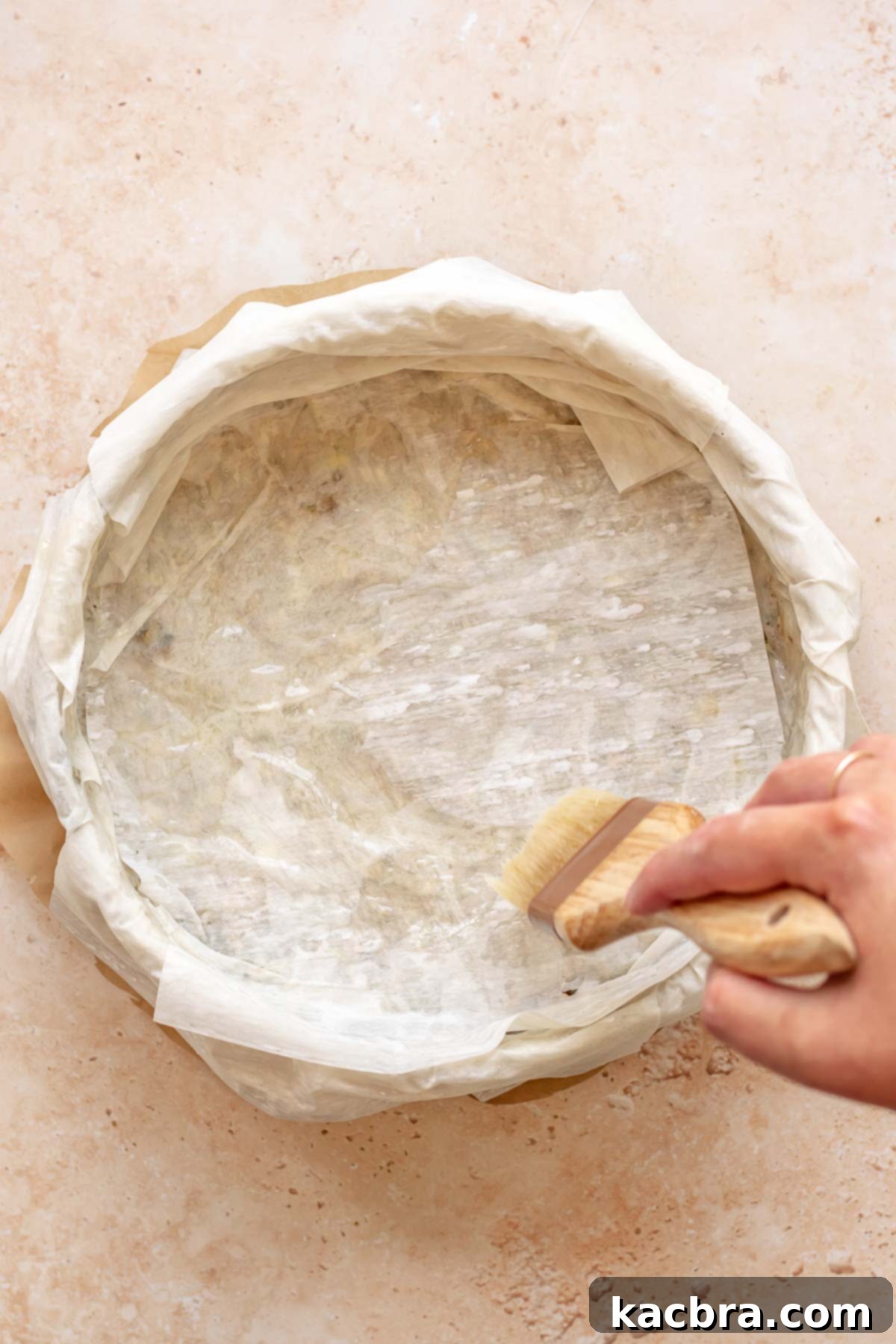 Golden Honey Baklava Dream Cake 10 A pastry brush applies butter to the final layer of phyllo dough in the pan.