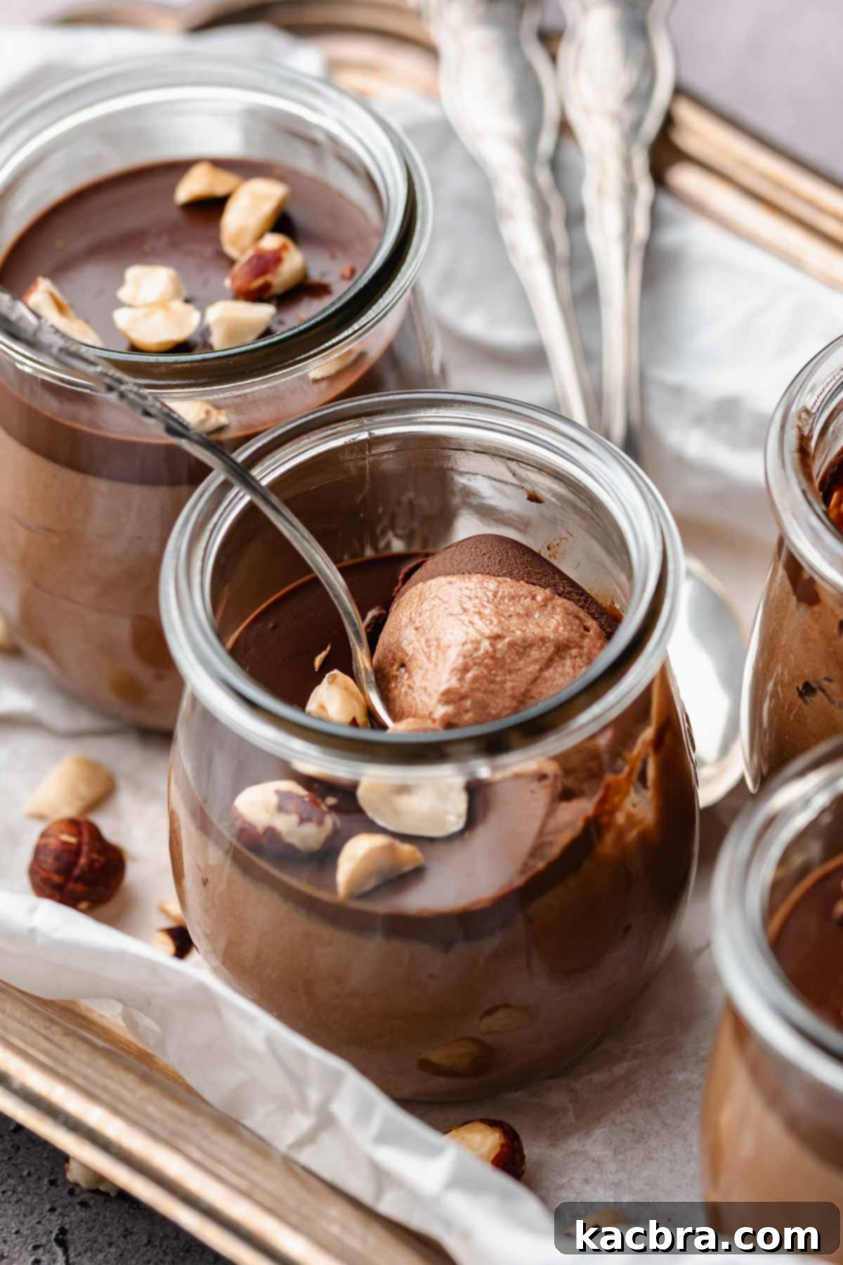 A spoon in a cup of Nutella mousse scooping some out.