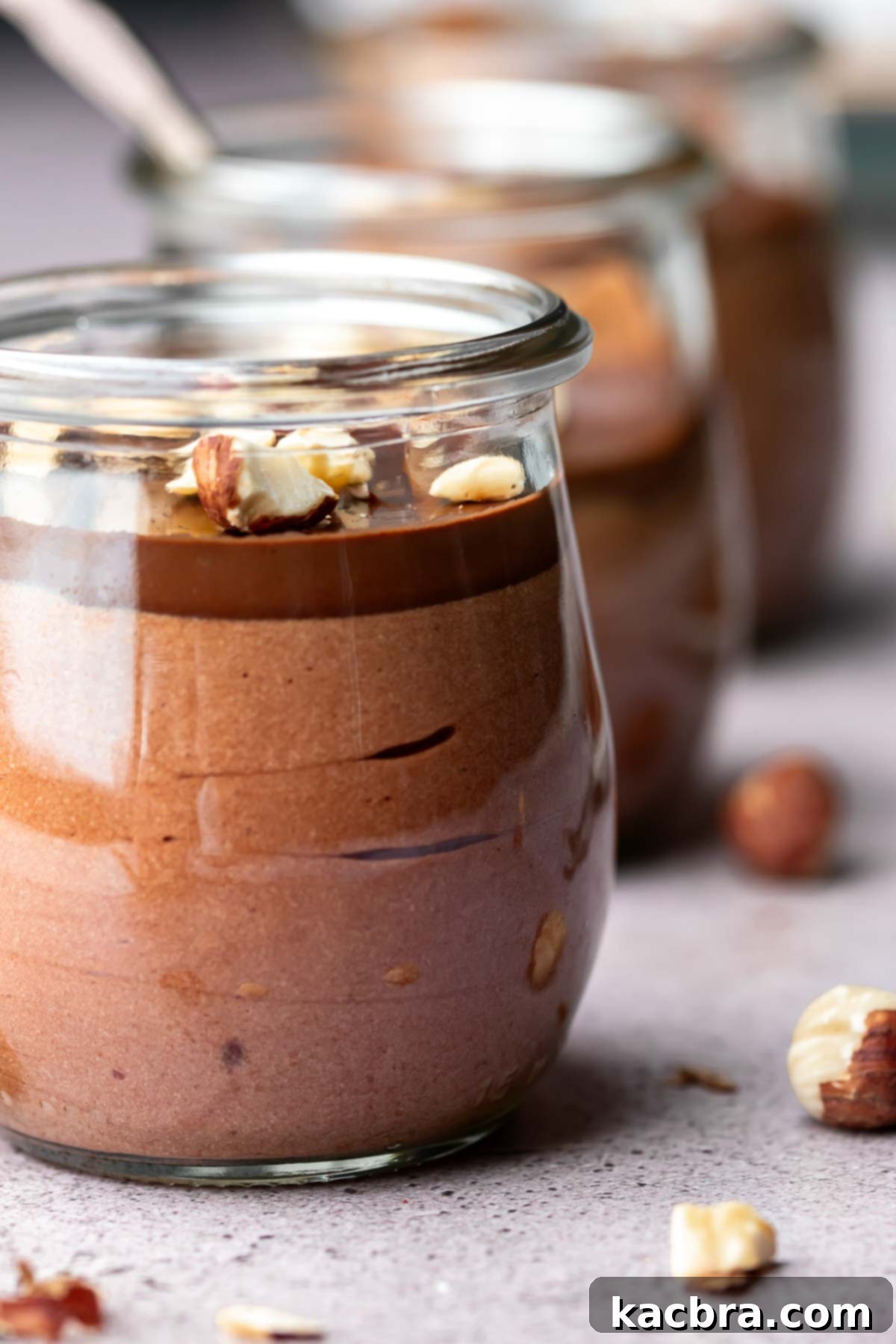 Nutella mousse in a weck jar with chocolate ganache and hazelnuts on top.