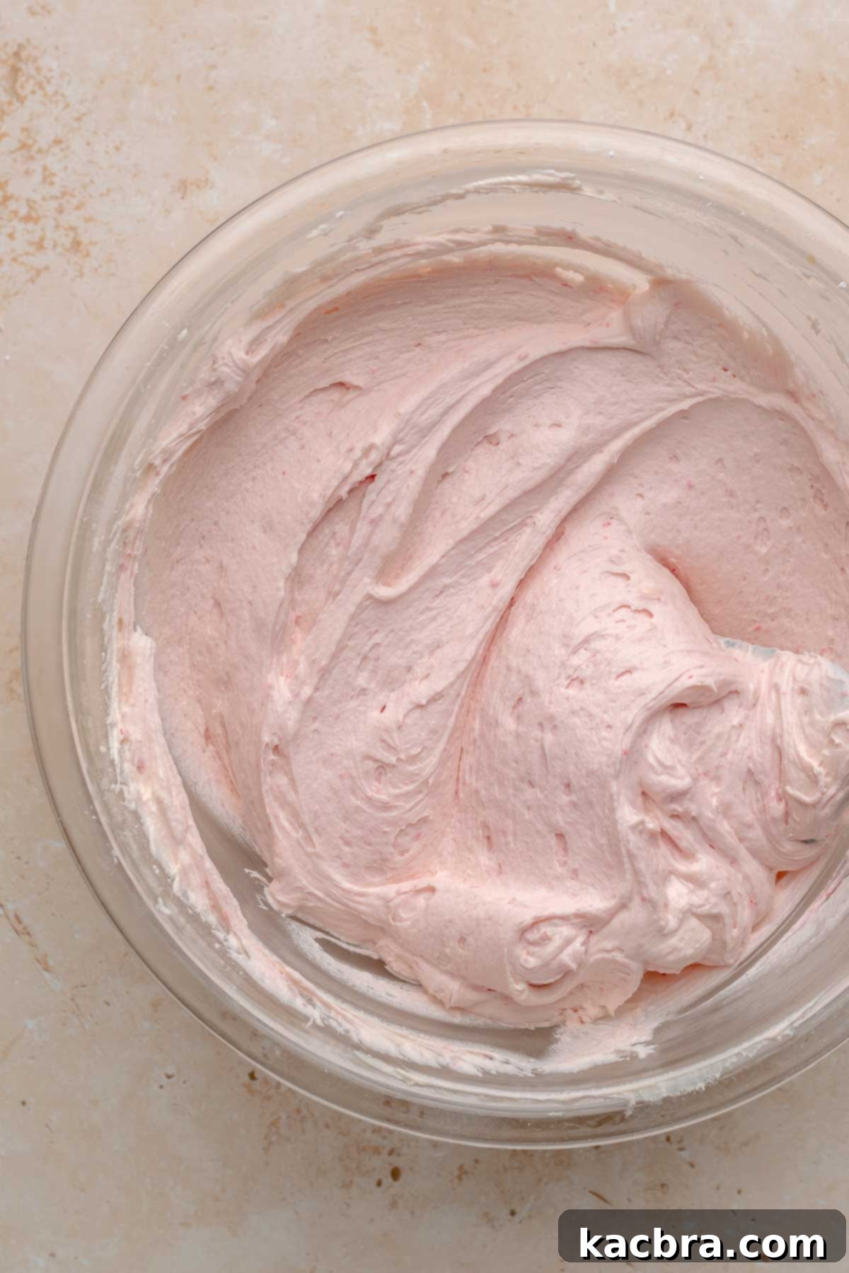 Ruby and Ivory Cupcake Delights 14 A bowl of white chocolate frosting, now tinted a delicate pink after the addition of raspberry sauce, ready for piping.