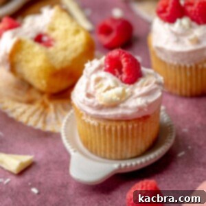 Raspberry white chocolate cupcake on a small plate.