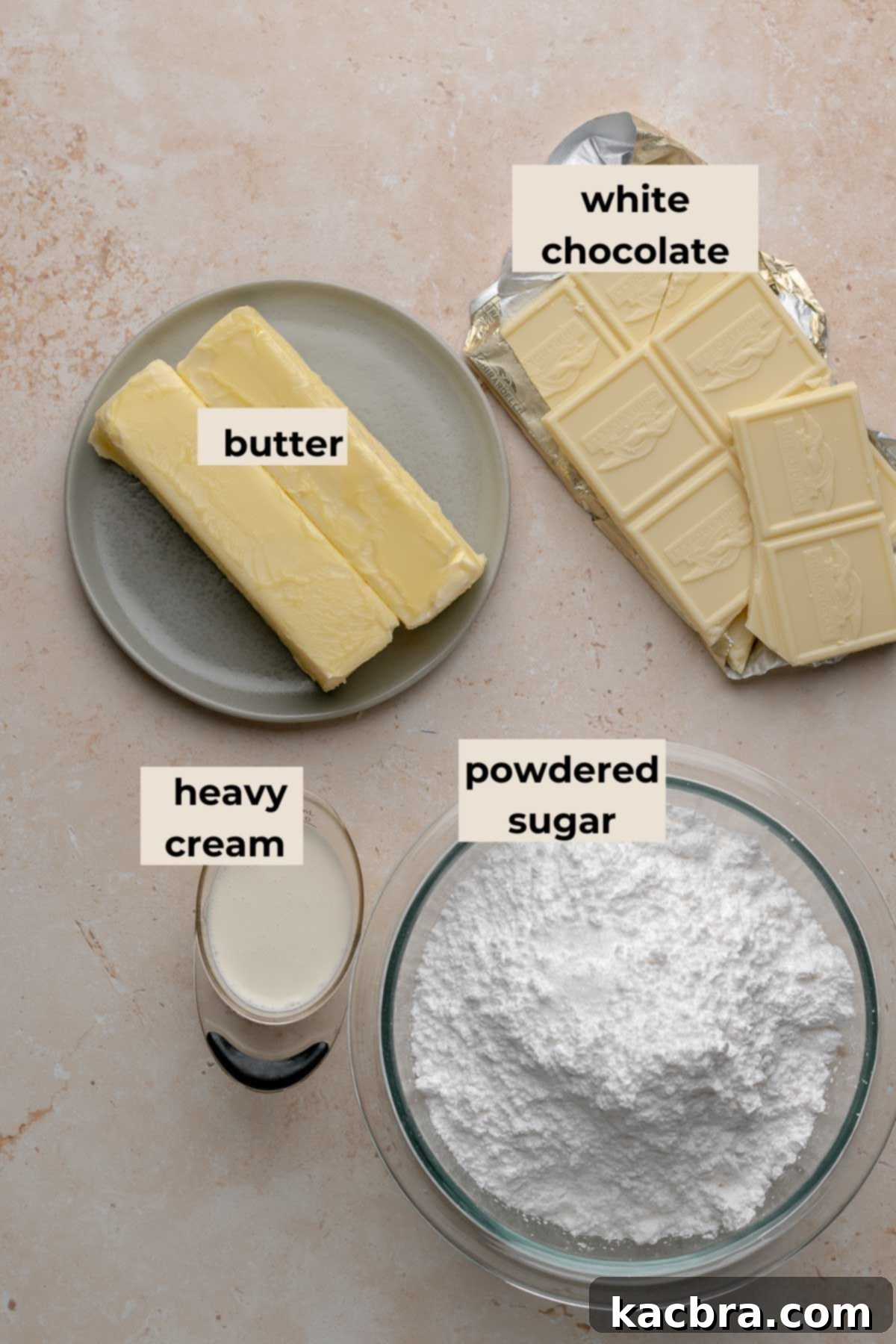A flat lay photograph of ingredients for rich white chocolate frosting, featuring powdered sugar, butter, and white chocolate bars.