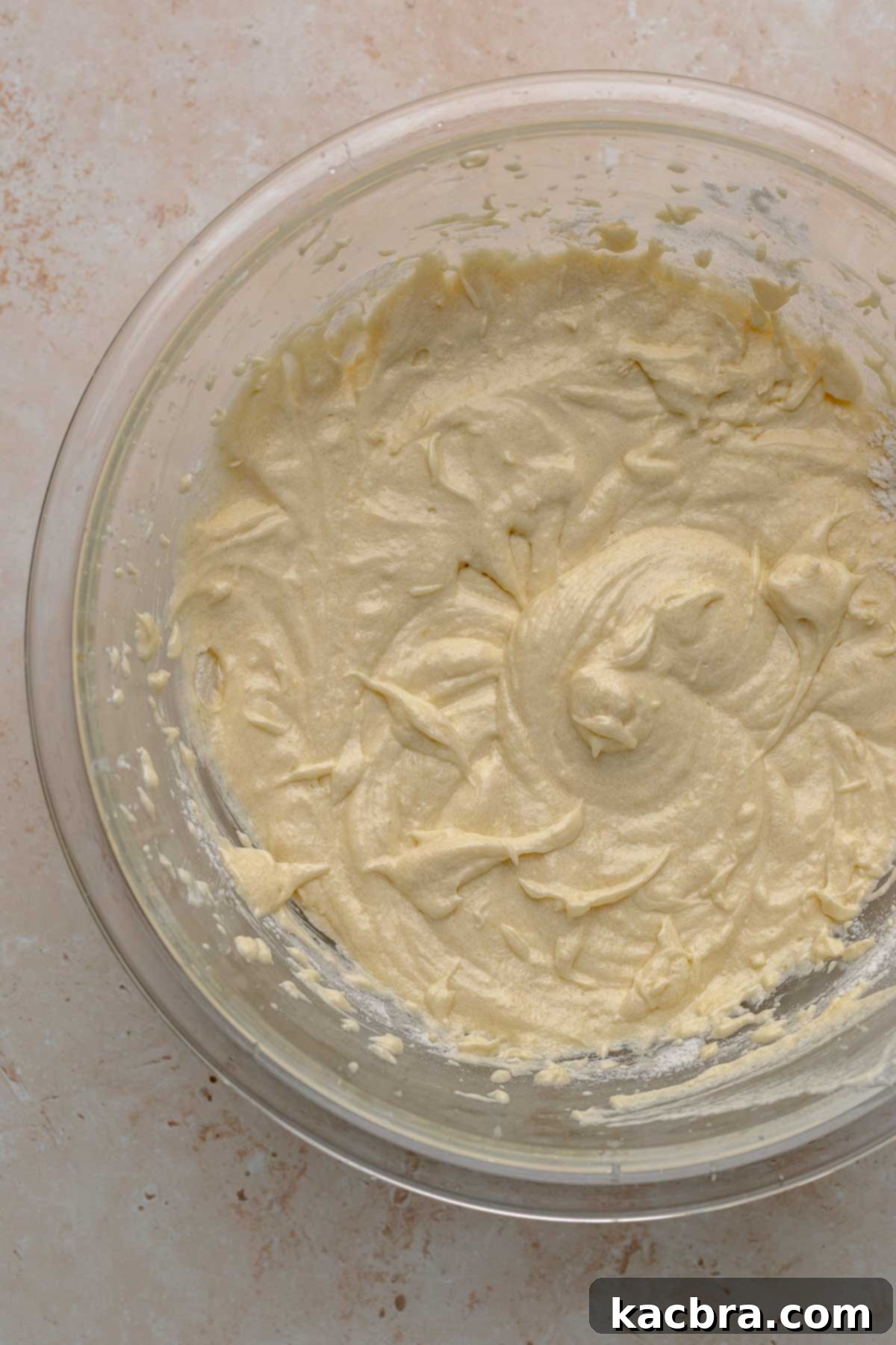 Ruby and Ivory Cupcake Delights 8 Half of the dry ingredients, primarily flour, have been added to the creamed butter and sugar mixture, showing a partially combined cupcake batter.