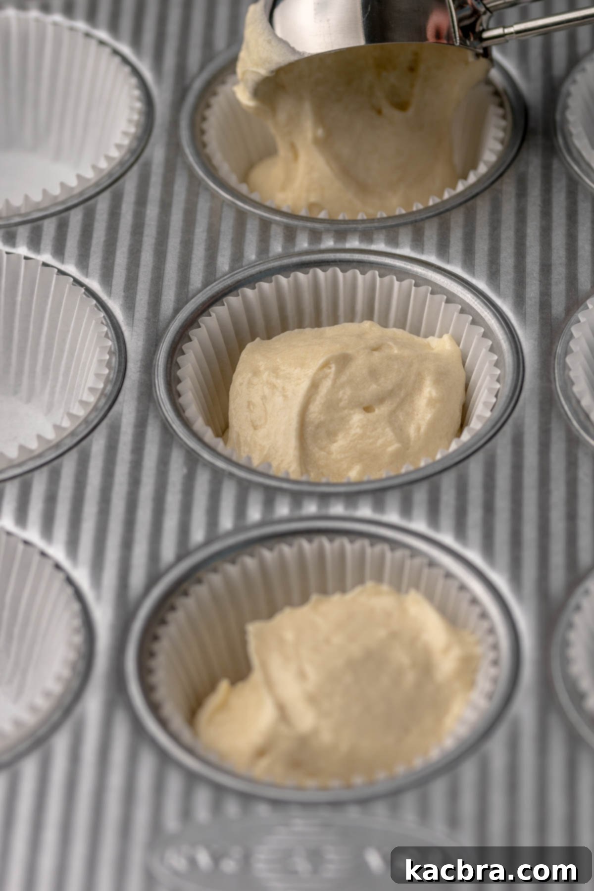 Ruby and Ivory Cupcake Delights 10 Cupcake batter neatly scooped into paper liners arranged in a muffin tin, ready for baking.
