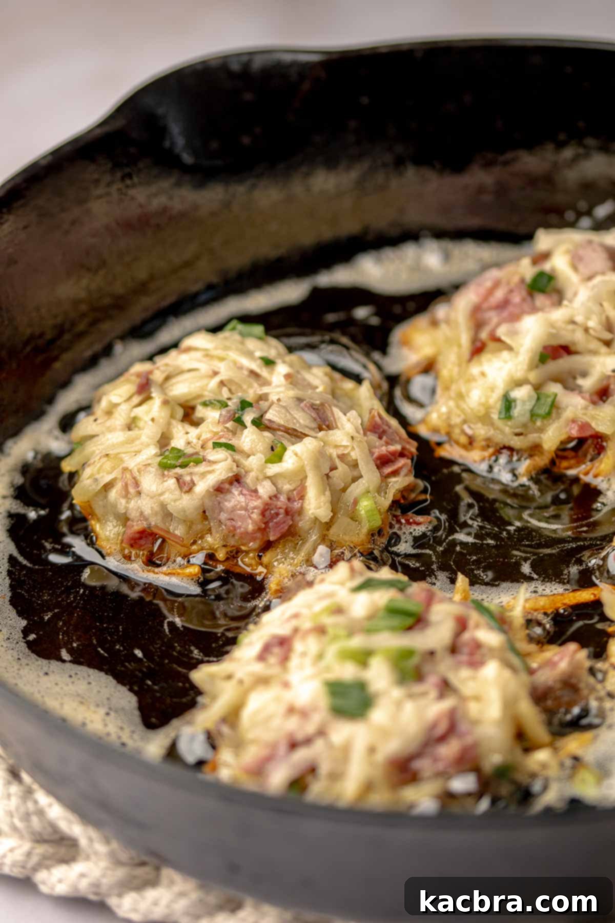 Corned beef fritters added to a hot pan of oil.