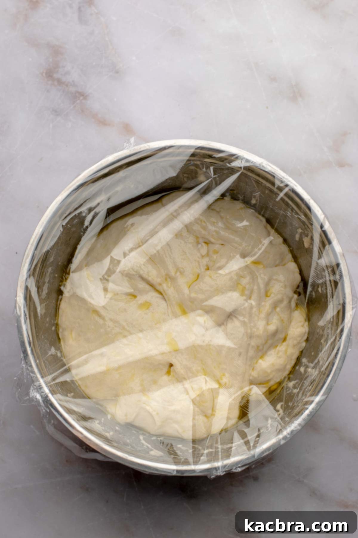 Aromatic Pesto Focaccia 10 Focaccia dough in a bowl covered with plastic wrap (pre-rise).