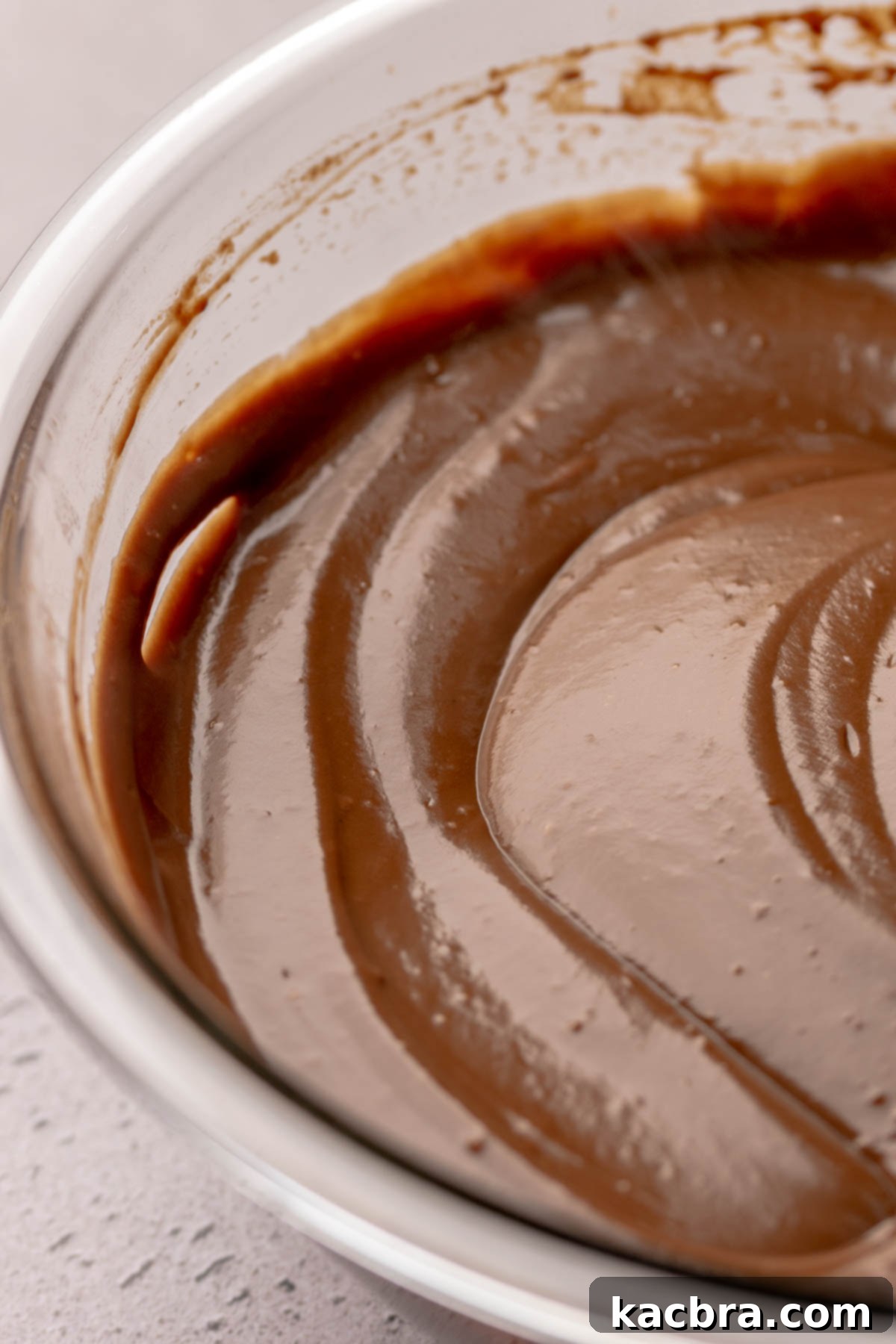 The finished, glossy, and smooth chocolate pudding in a bowl, ready to be poured.