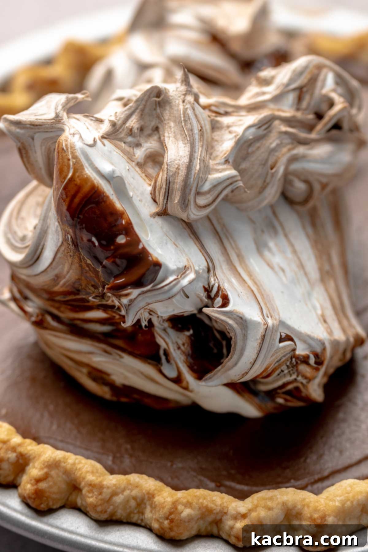 Marbled chocolate meringue being dropped onto the top of the chilled chocolate pie.