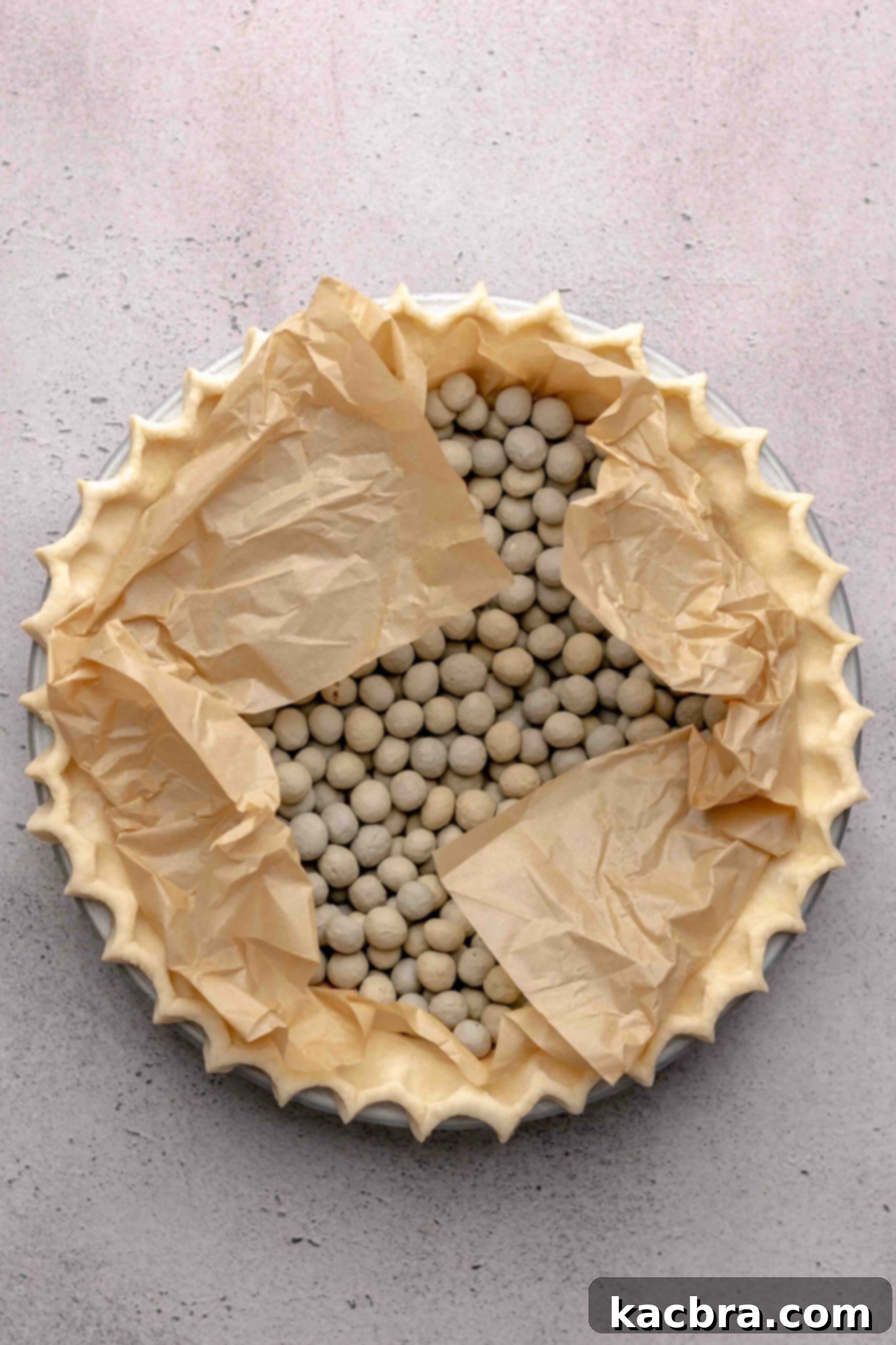 Pie crust with parchment paper and pie weights in it.