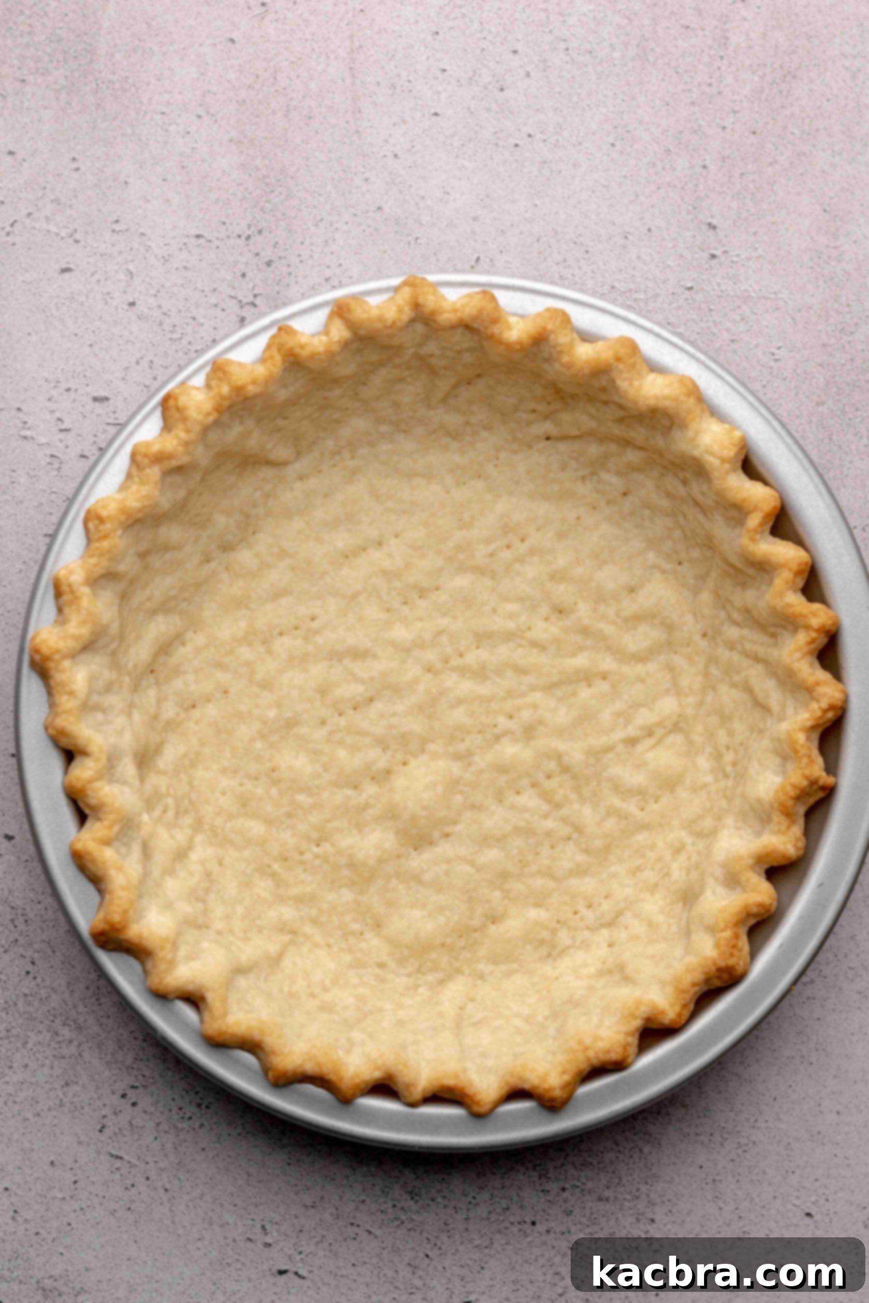 A fully blind-baked sweet pie crust, golden brown and ready to be filled.