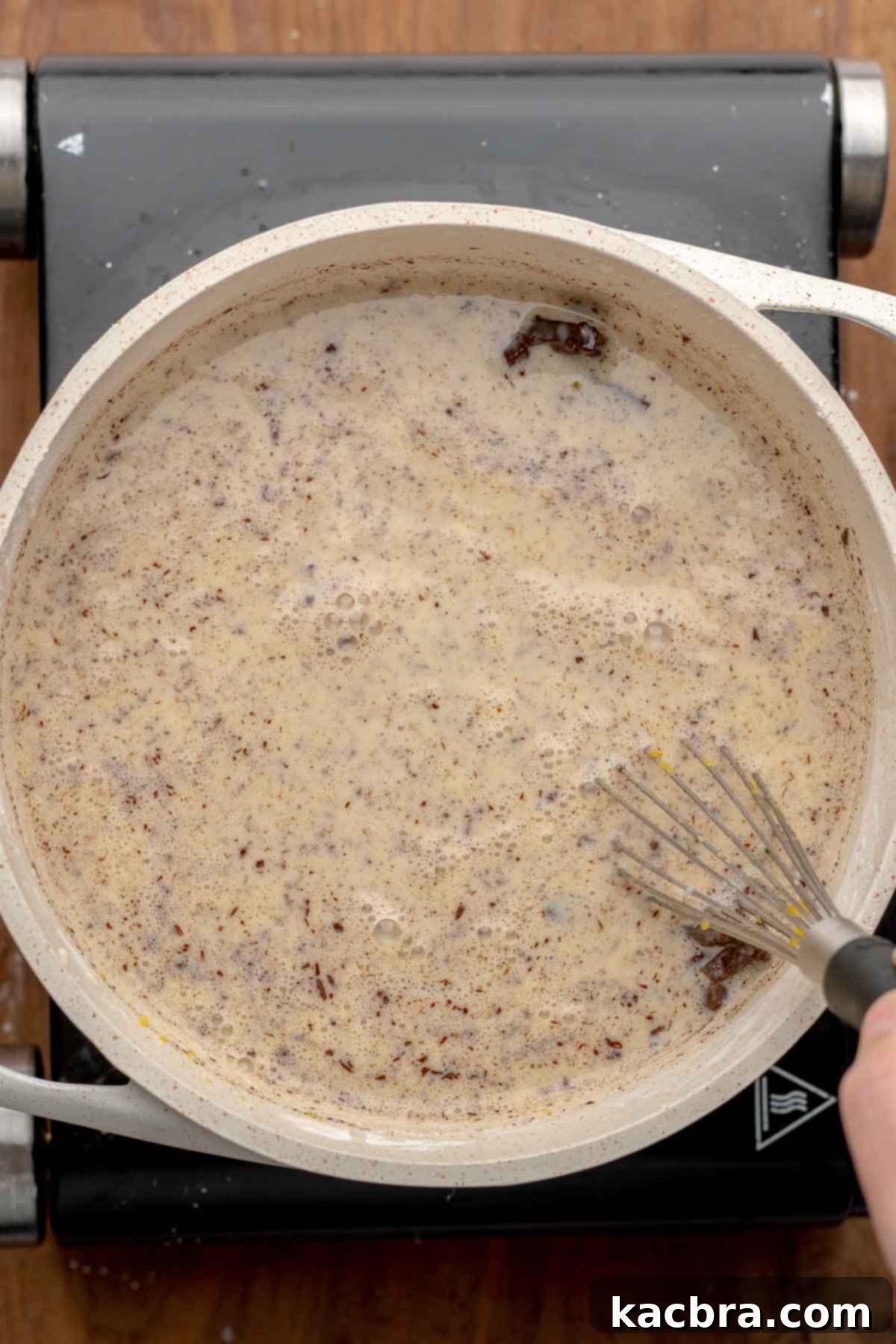 Chocolate pudding ingredients being mixed together in a pot with a whisk.