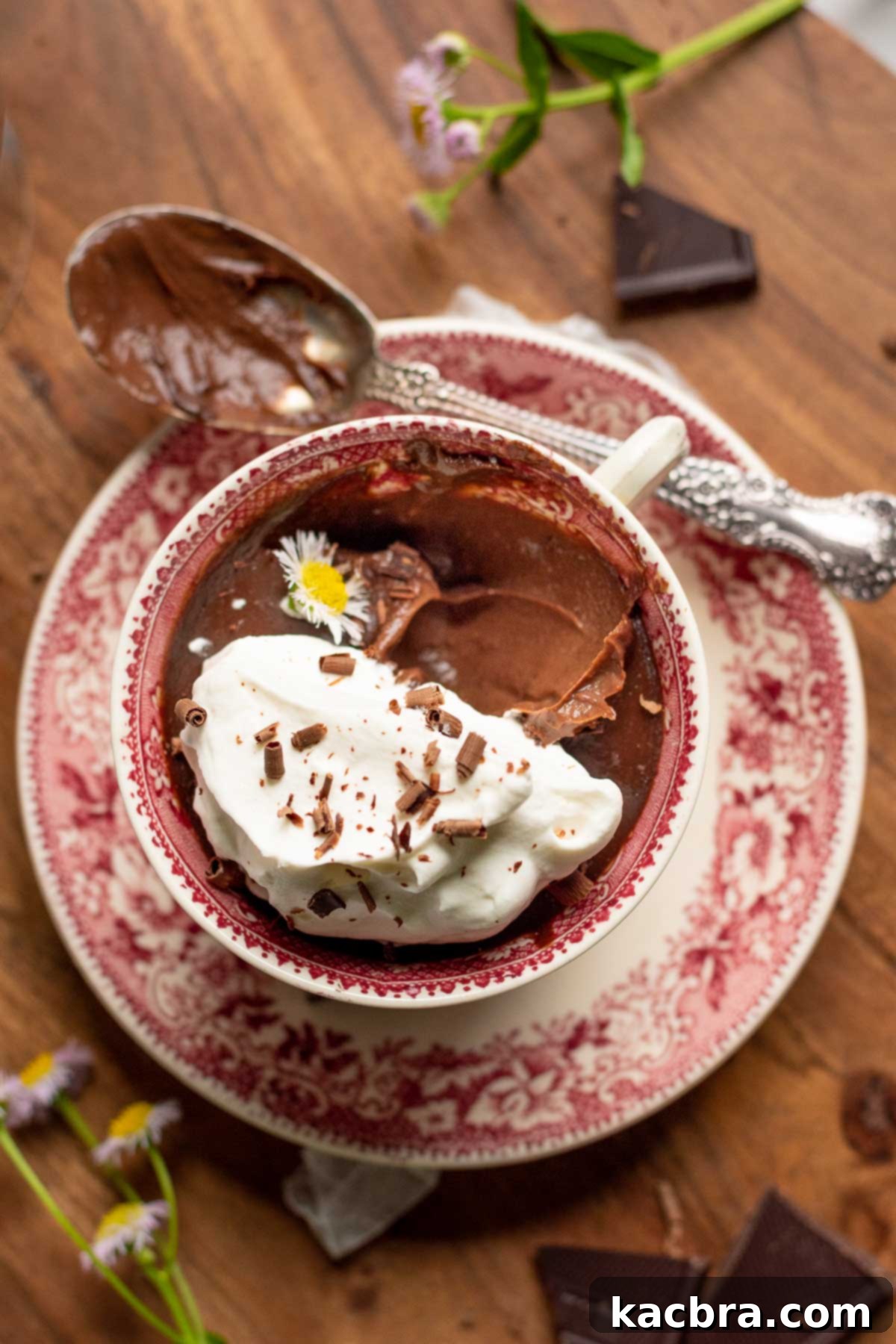 Pots de creme in a tea cup with the spoon on the side.
