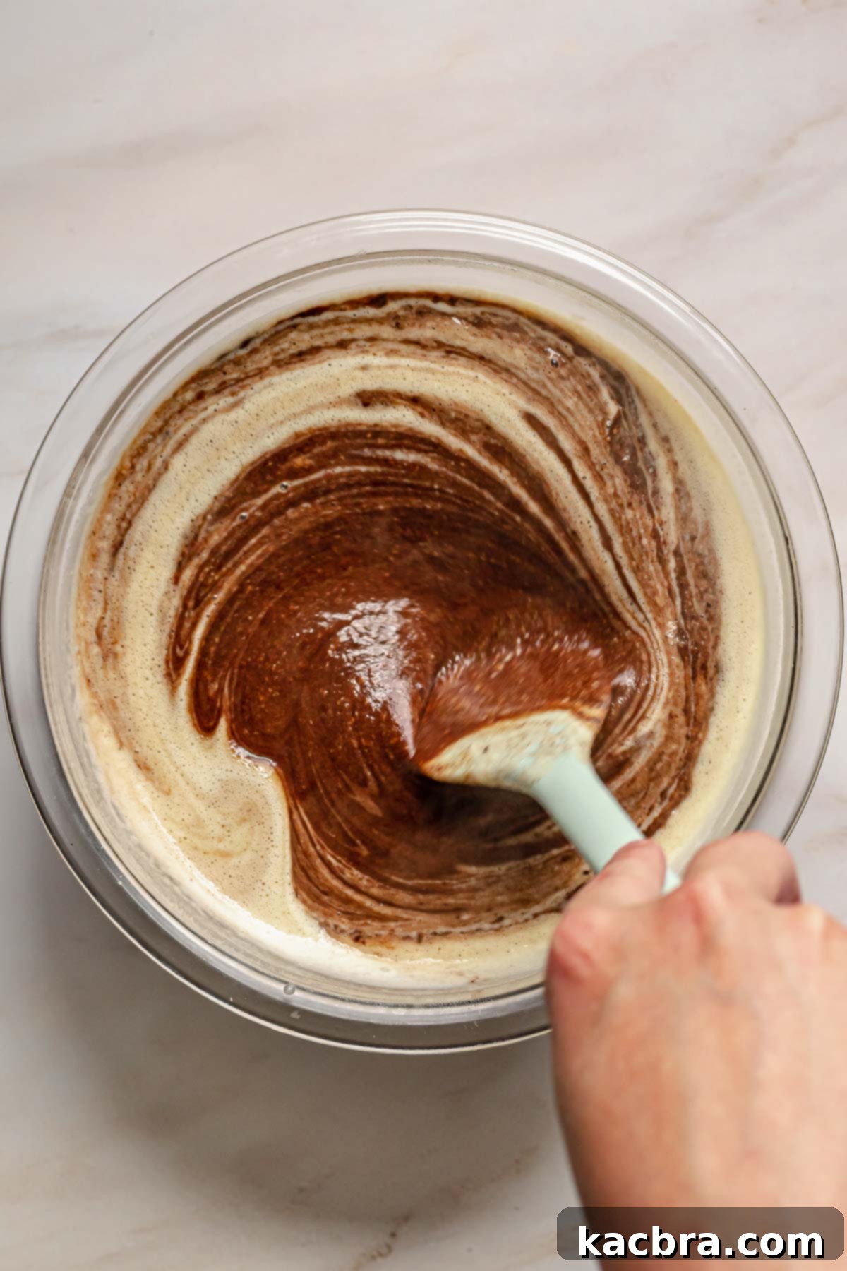 Stirring chocolate custard with a rubber spatula.