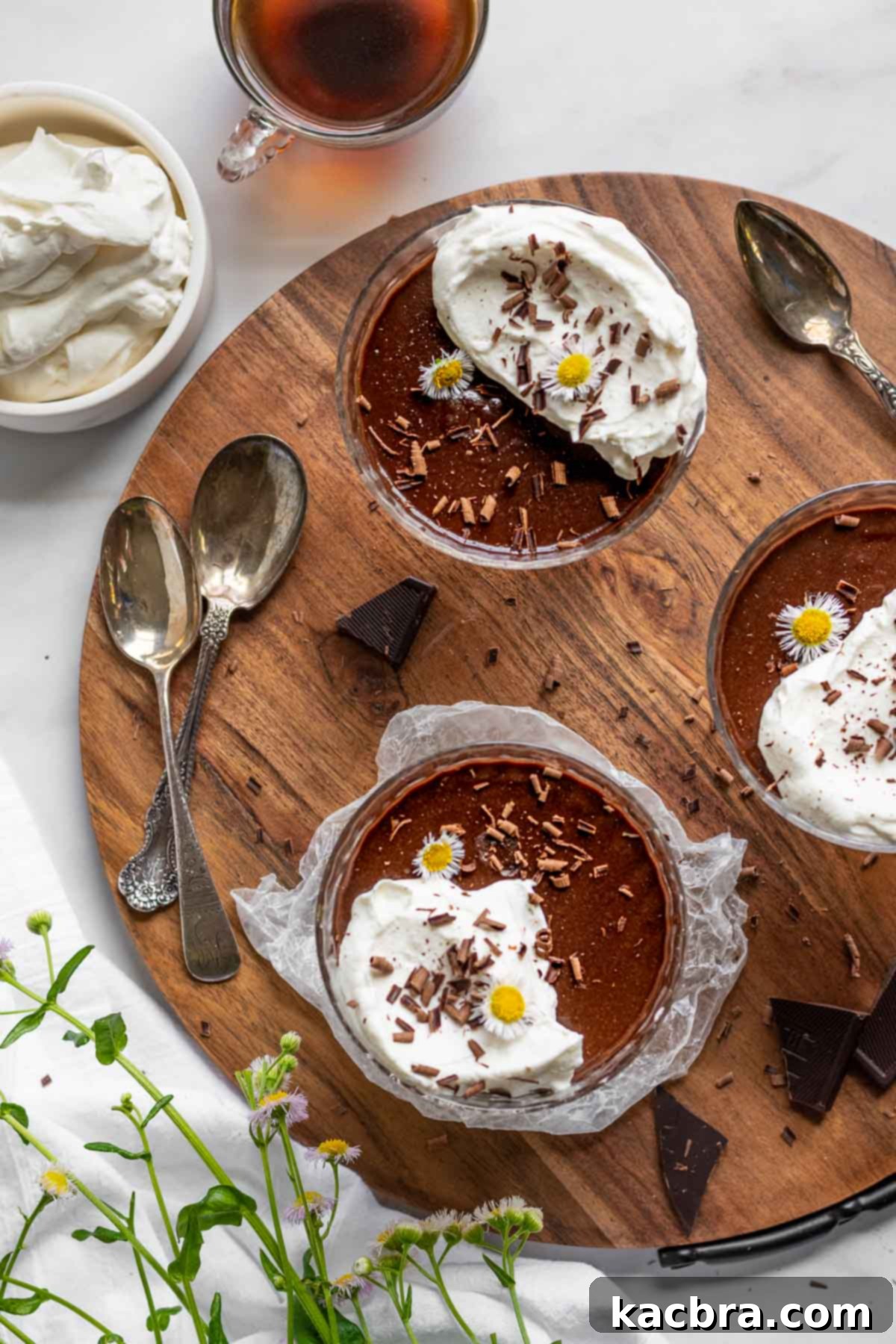 Dark chocolate pots de creme on a wooden board.