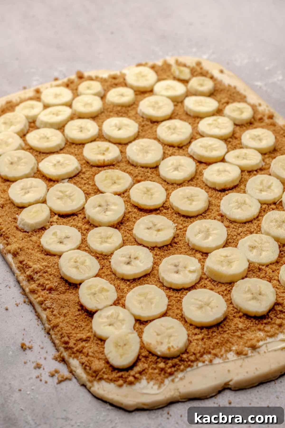 Fresh banana slices meticulously layered on top of the cinnamon sugar mixture on the dough.