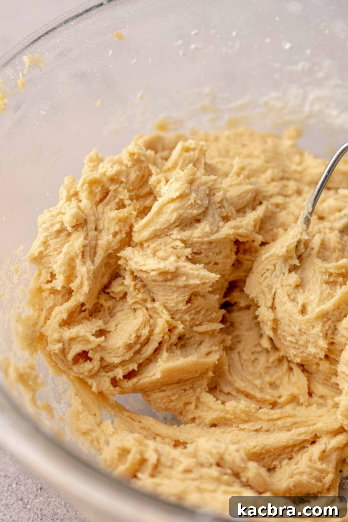 Peanut butter frosting ingredients mixing in a stand mixer bowl, becoming smooth and creamy.