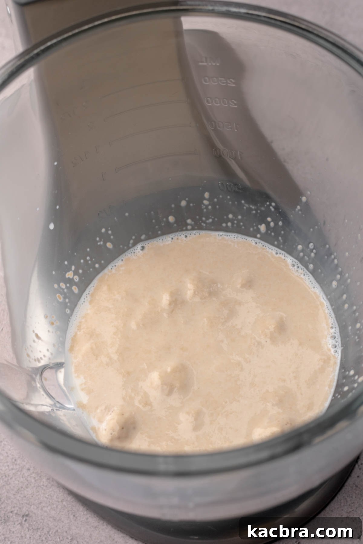 Yeast activated and foamy in a bowl, indicating it's ready for dough preparation.