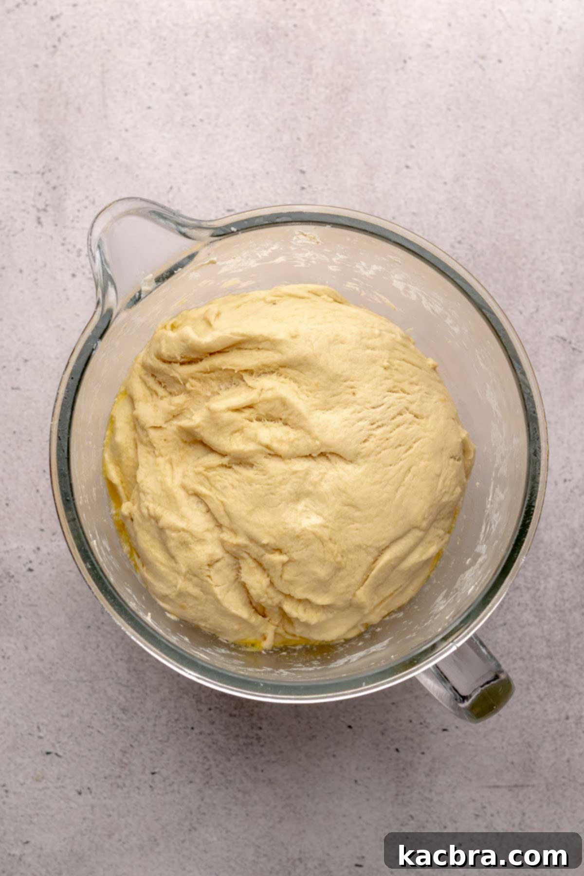 Perfectly risen cinnamon roll dough in a bowl, indicating it's ready for the next stage.