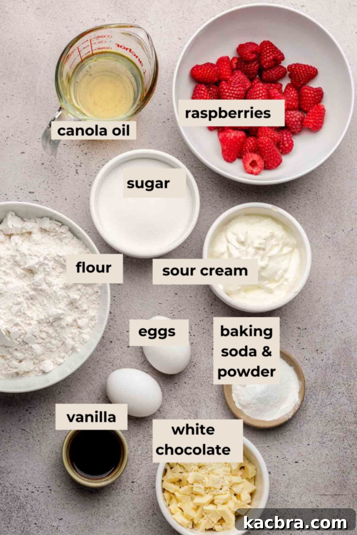 A colorful array of ingredients meticulously arranged for baking delectable white chocolate raspberry muffins, featuring fresh berries, chocolate, and dry components.