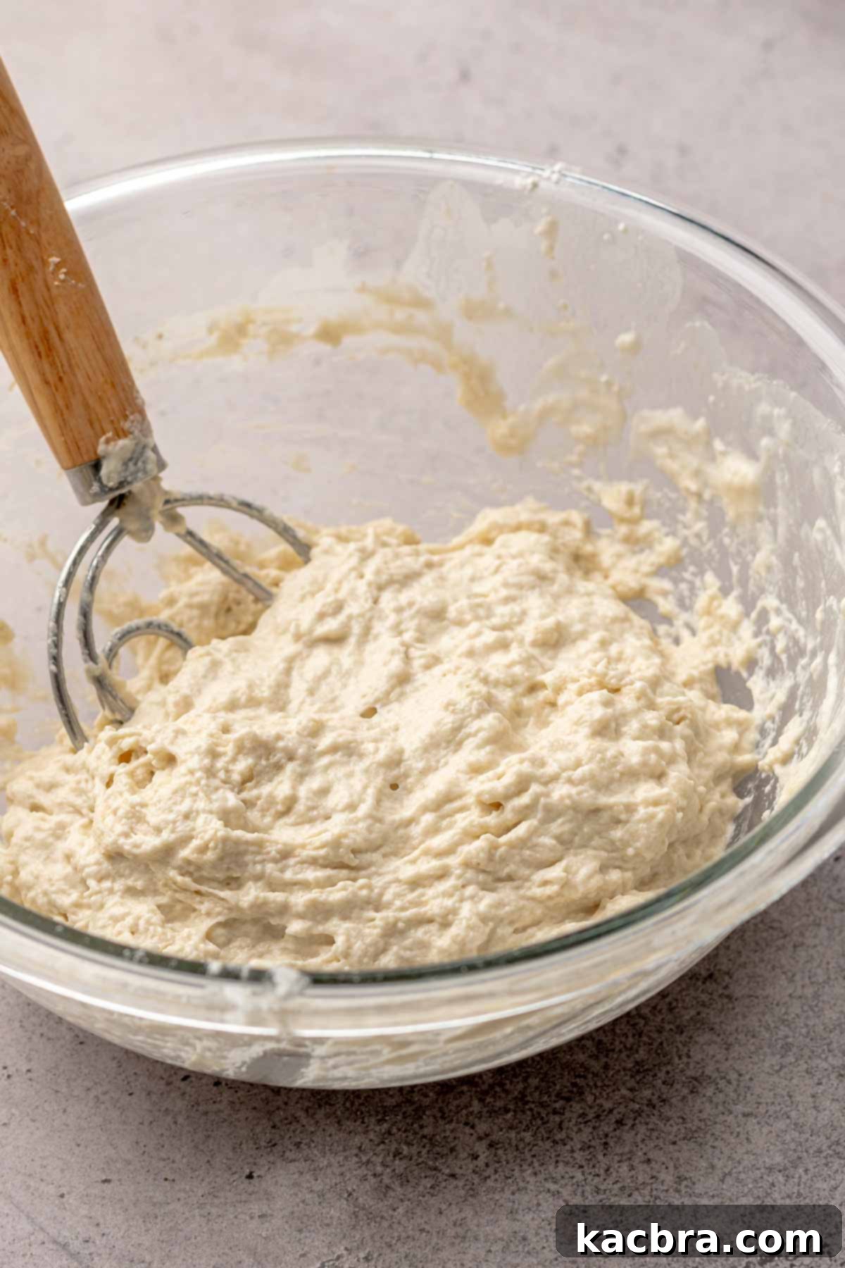 A dough whisk in a bowl of dough.