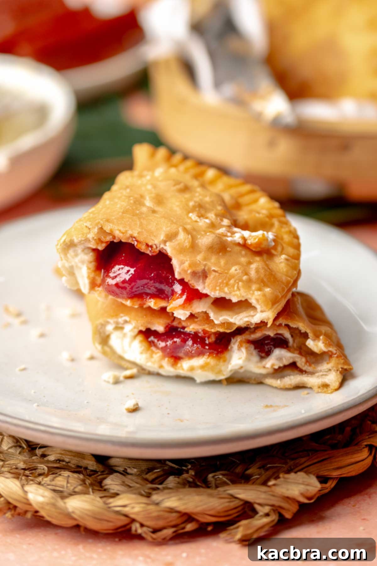 Cheese and guava empanada broken in half and stacked on a plate.