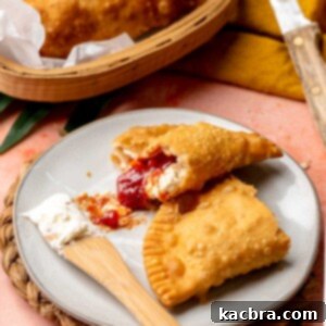 Guava and cheese empanada broken open on a plate.