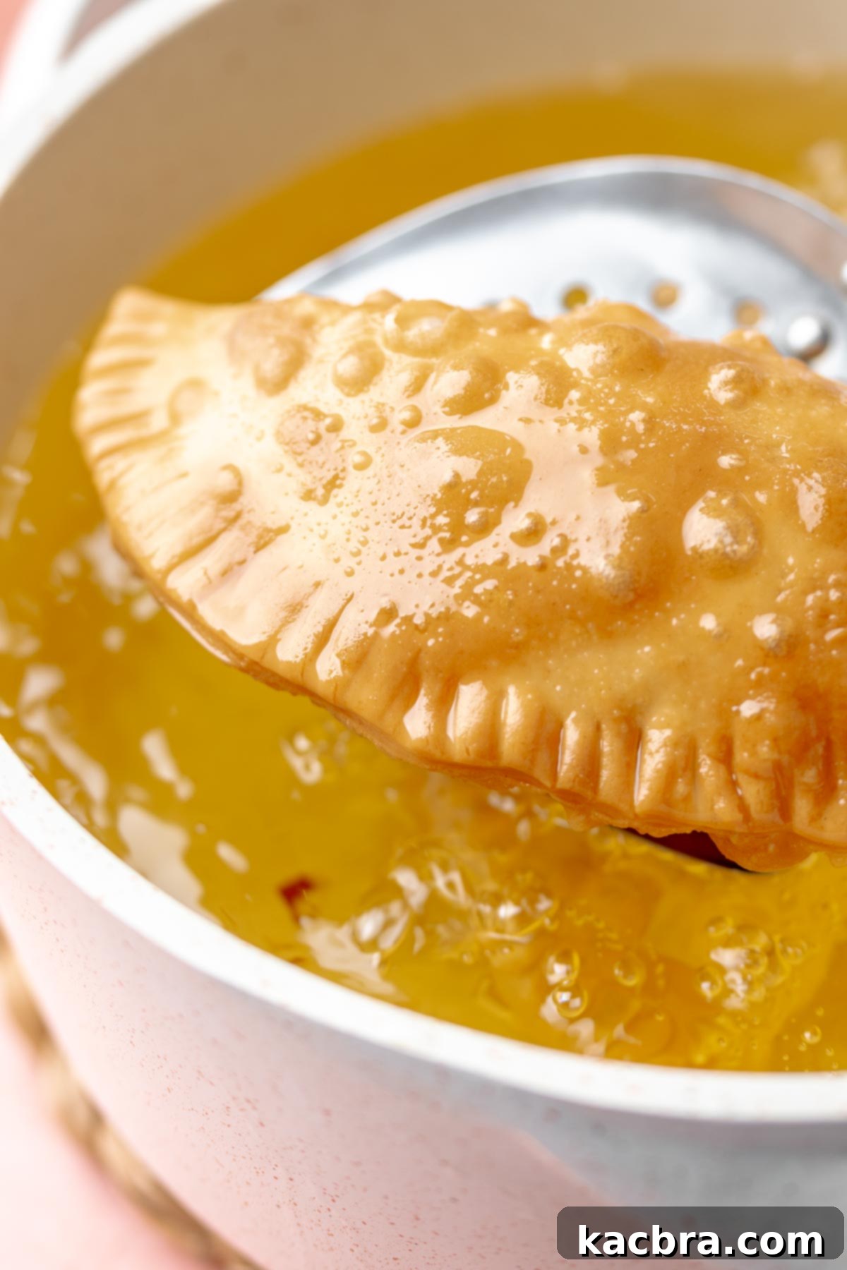 A fried empanada in hot oil.