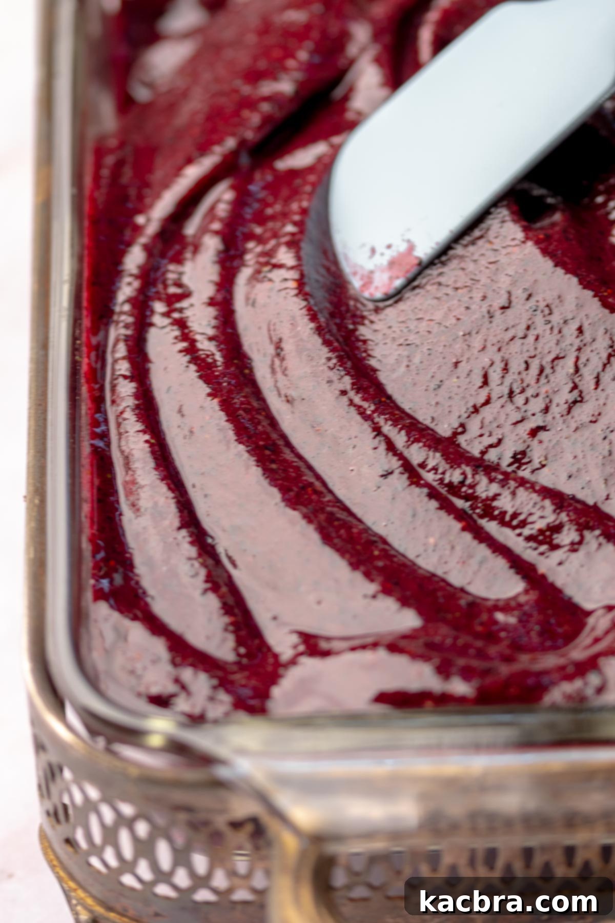 A spatula spreads blueberry sorbet into a loaf pan.