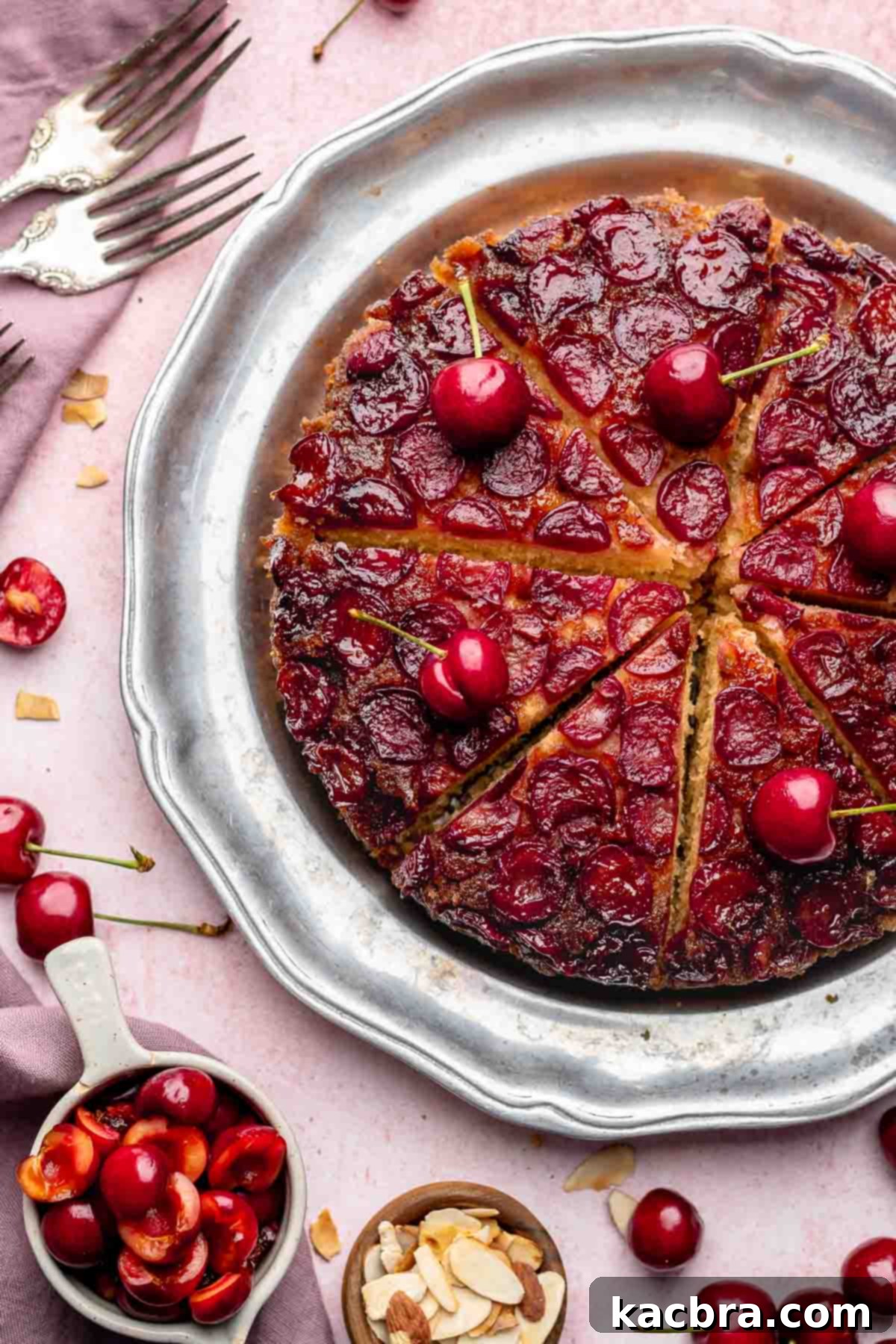 Sliced cherry upside down cake on a platter, showcasing the beautiful fruit layer.
