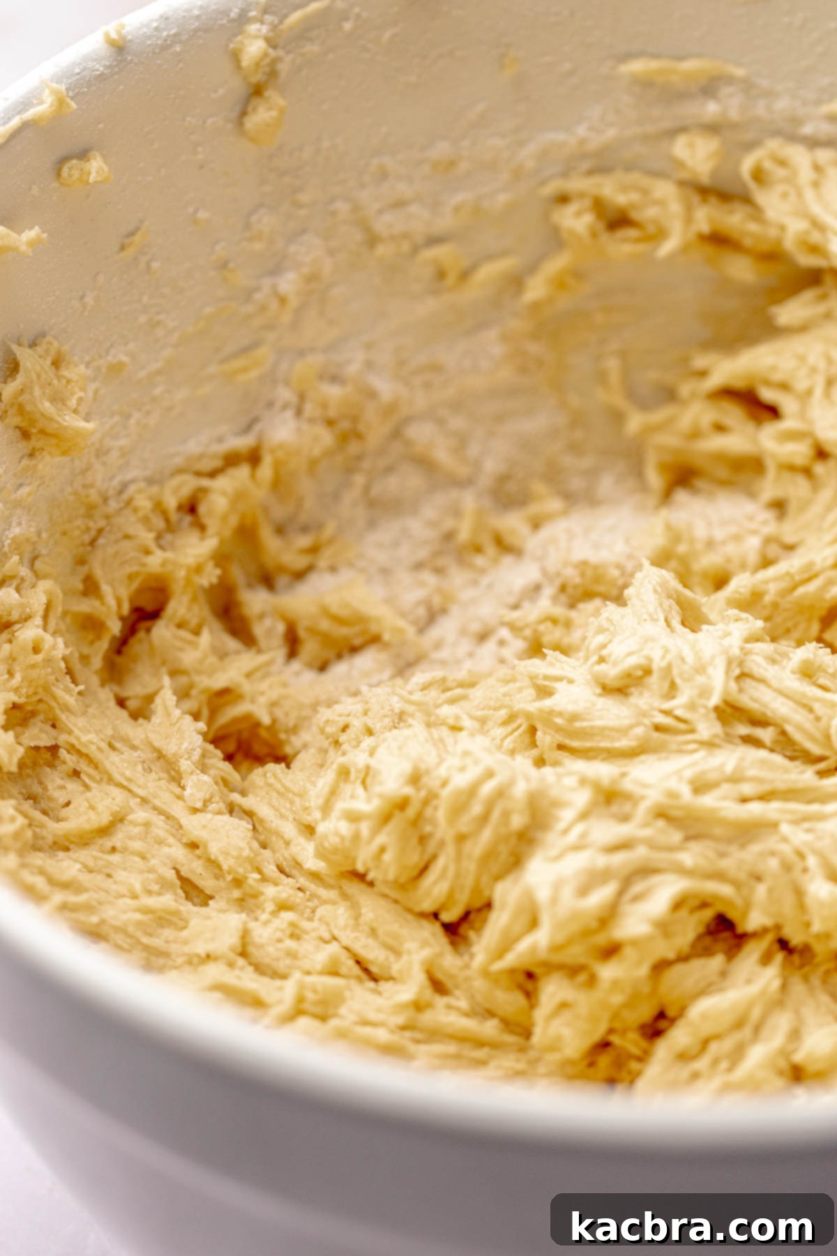 Flour mixture, baking powder, and salt added to the wet ingredients in a bowl.