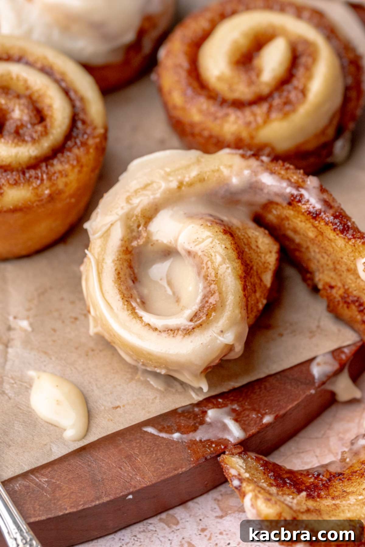A partially unwrapped frosted mini cinnamon roll.