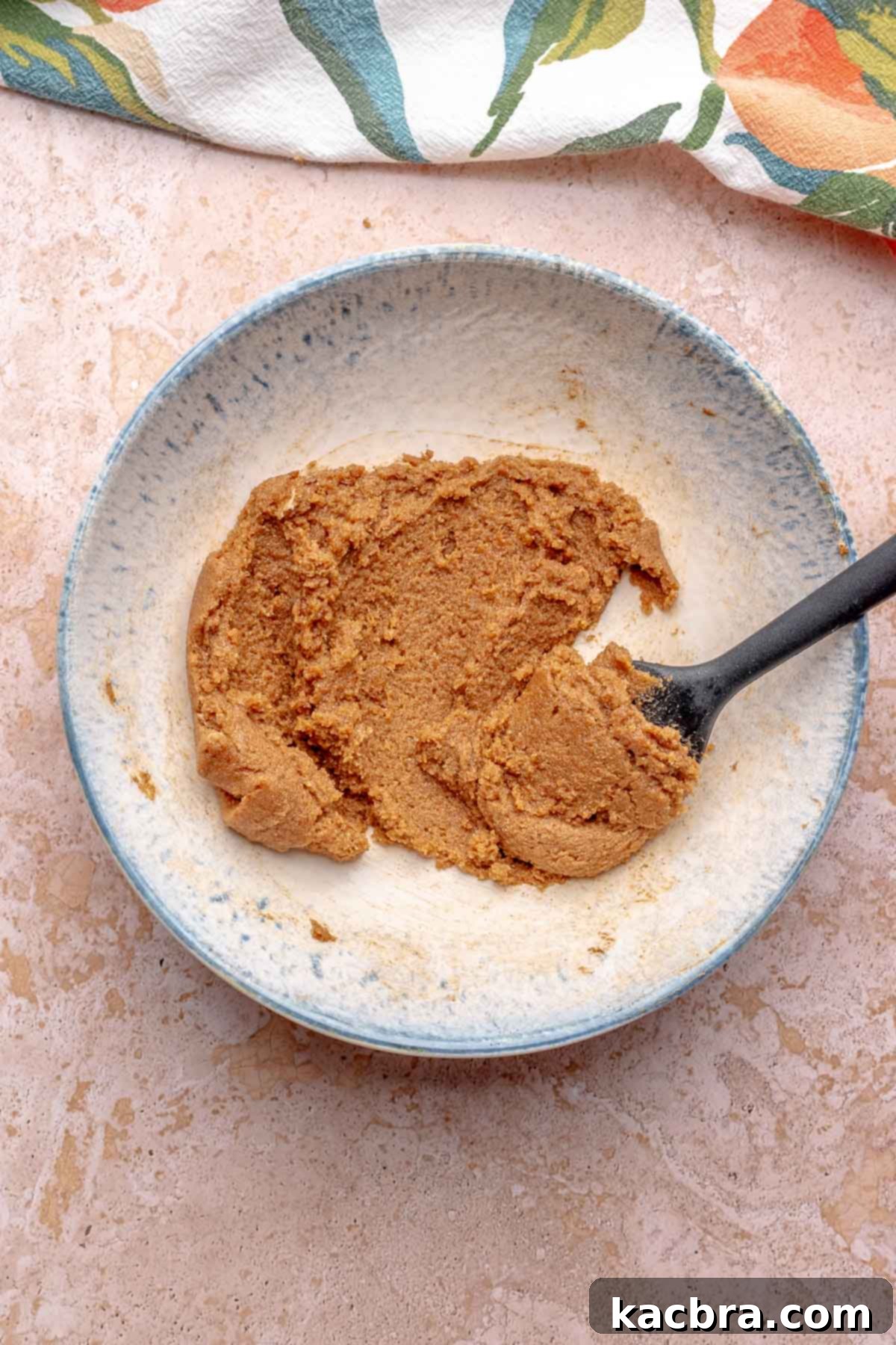 Cinnamon roll filling in a bowl with a rubber spatula.