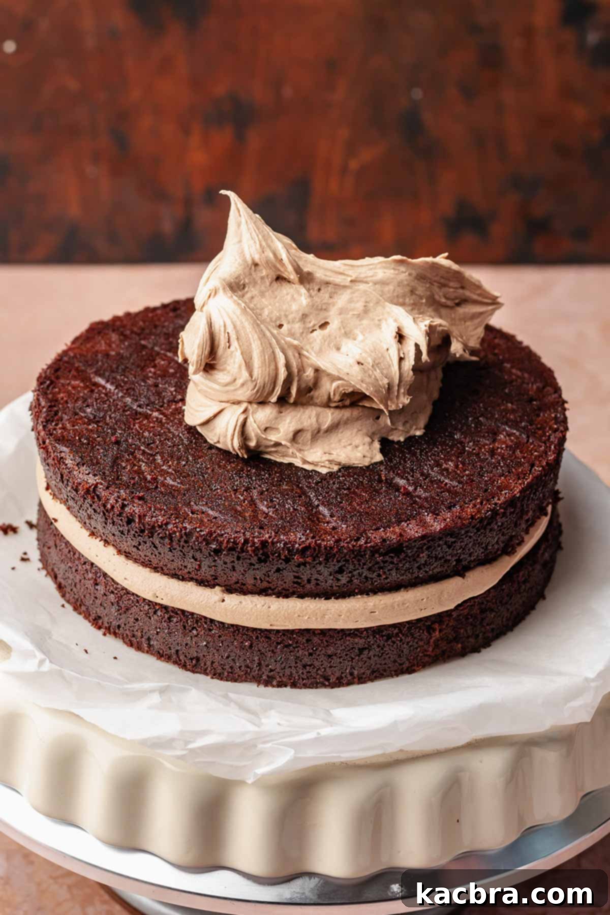 A dollop of nutella buttercream on top of a two layer cake.