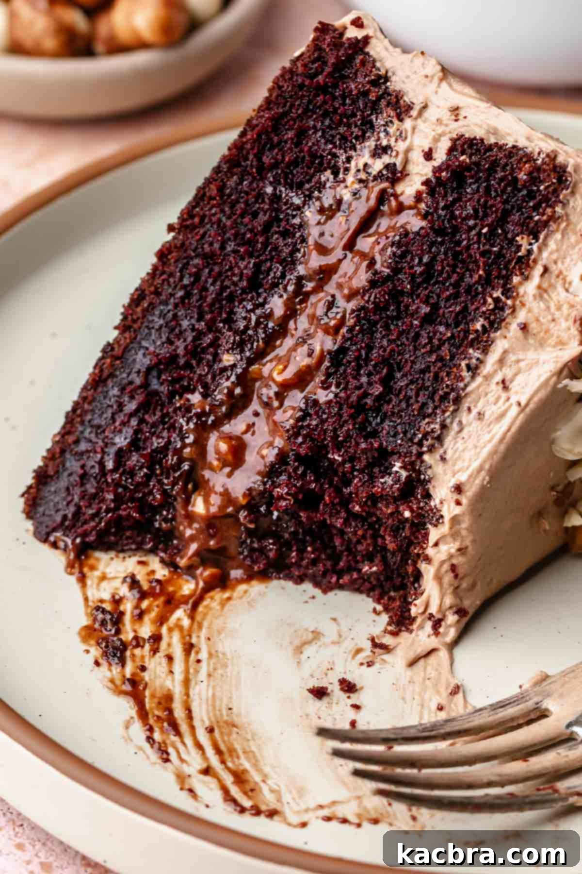 A slice of chocolate hazelnut cake with a bite removed.