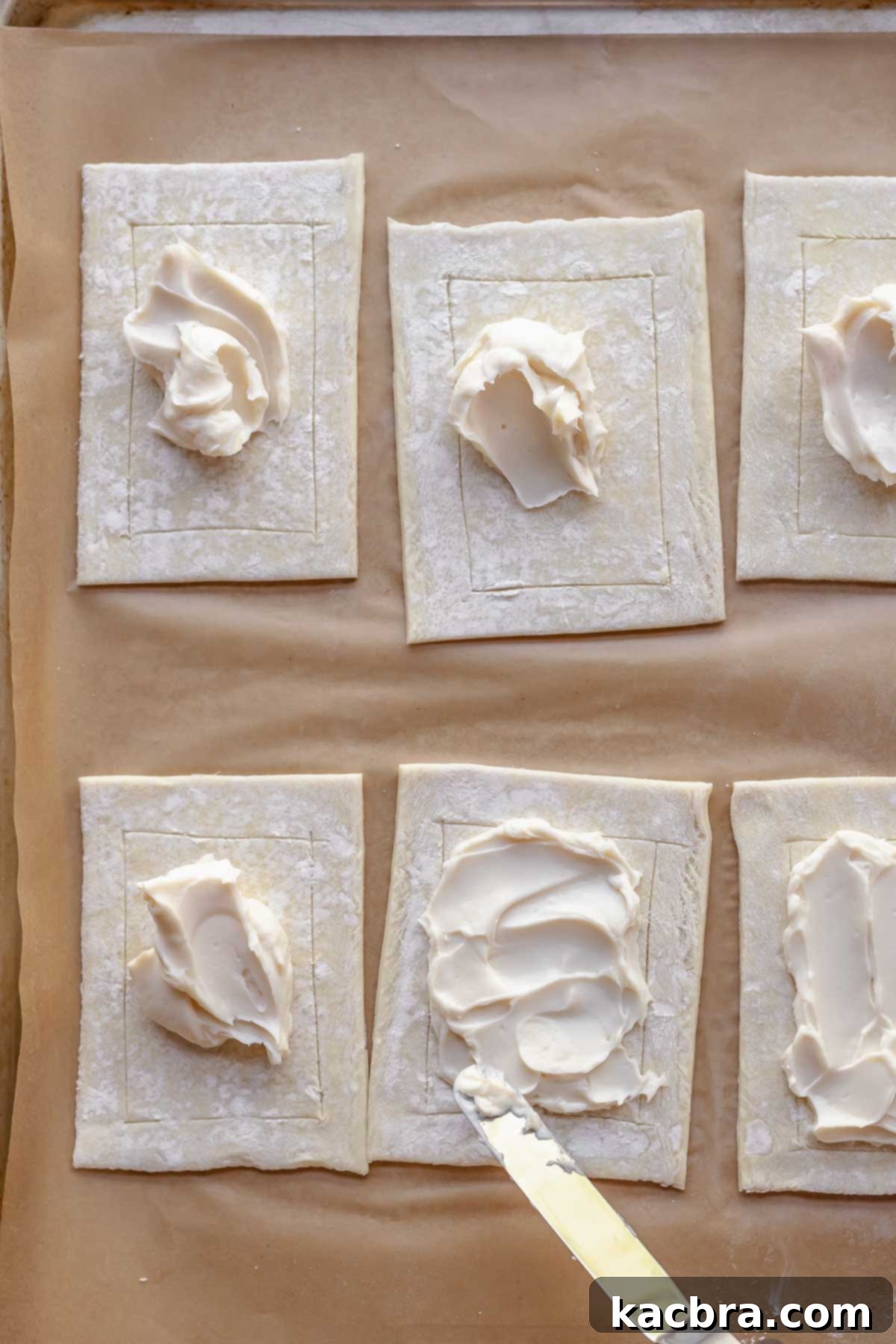 Spreading cream cheese onto the pastry.