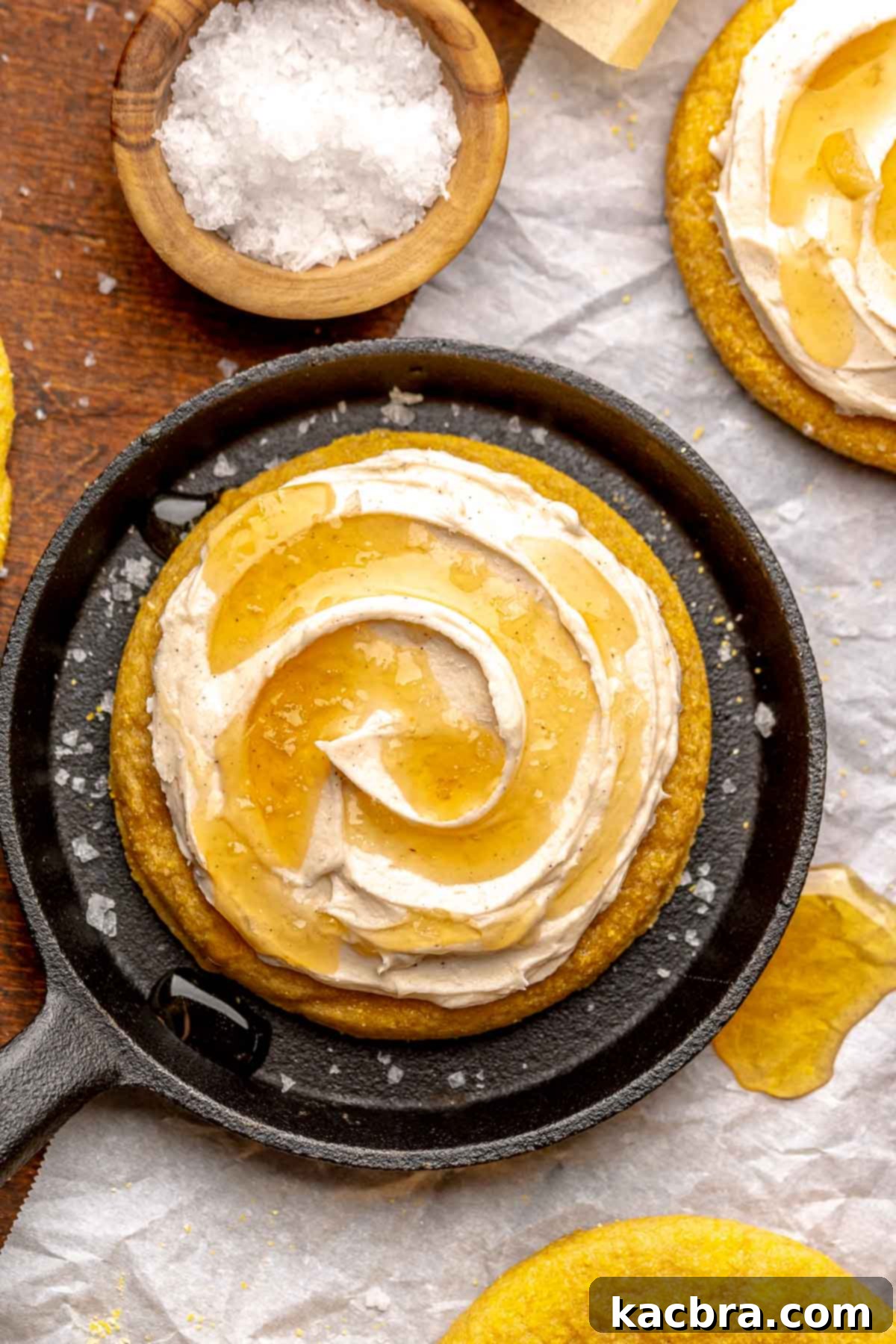 Warm Cornbread Cookies with Whipped Honey Butter 2 A frosted cornbread cookie in a mini cast iron skillet, showcasing its thick texture and generous frosting.