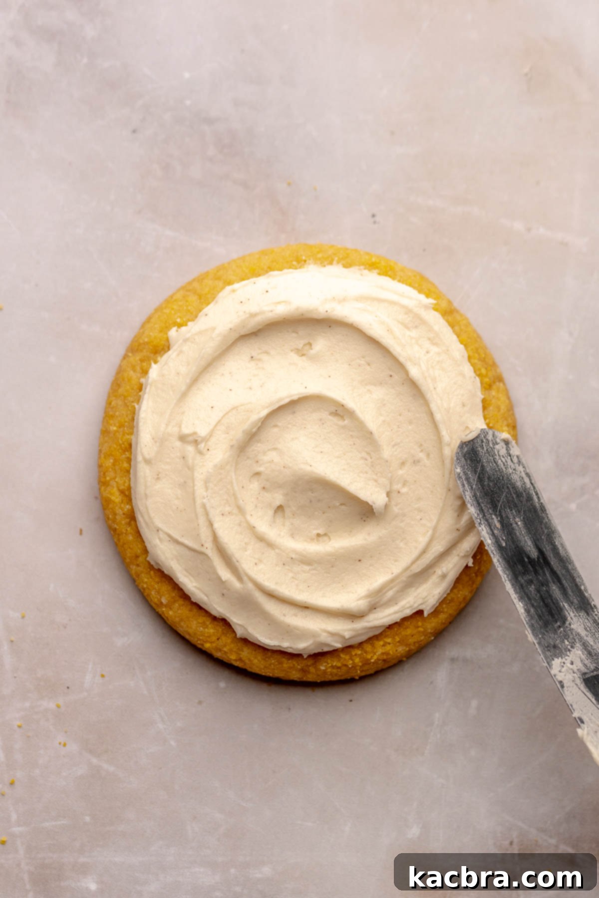 Warm Cornbread Cookies with Whipped Honey Butter 14 A spatula spreading luscious honey buttercream onto a cooled cornbread cookie, creating inviting swoops.