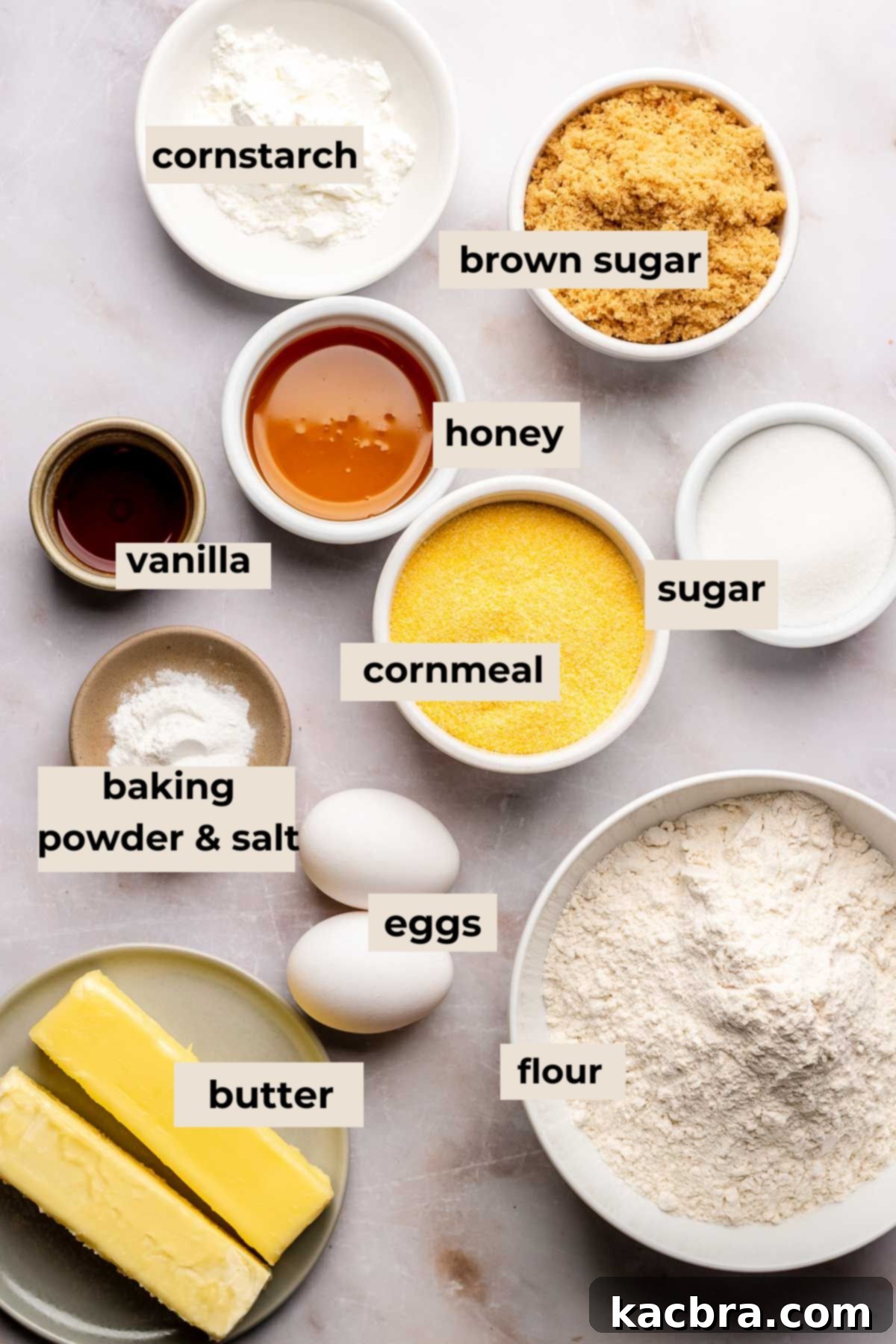 Warm Cornbread Cookies with Whipped Honey Butter 3 Various ingredients for cornbread cookies laid out on a wooden surface, including cornmeal, butter, honey, and flour.