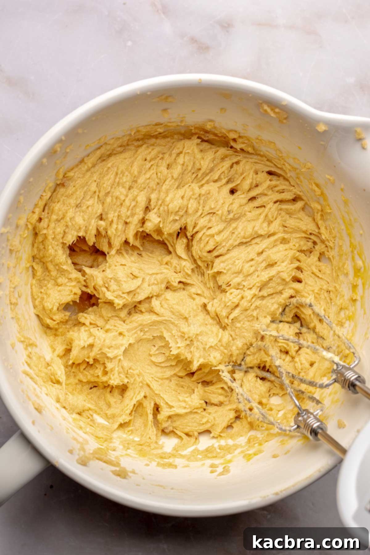 Warm Cornbread Cookies with Whipped Honey Butter 5 A hand mixer blending wet ingredients in a bowl, creating a smooth, cohesive mixture.