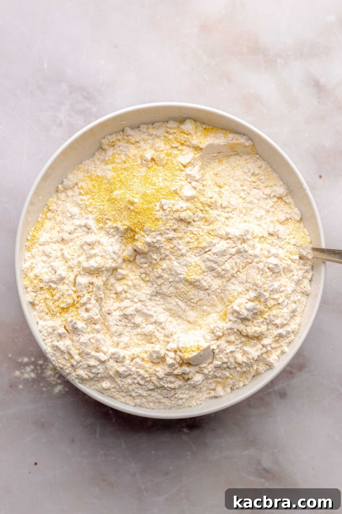 Warm Cornbread Cookies with Whipped Honey Butter 6 A bowl containing a thoroughly mixed combination of cornmeal and dry ingredients.