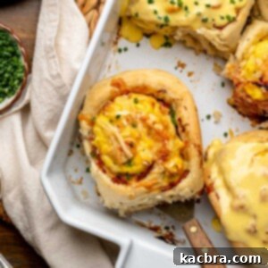 Fluffy Savory Rolls with Golden Hollandaise 19 A savory breakfast roll in a casserole dish, sitting on a spatula, ready to be served.