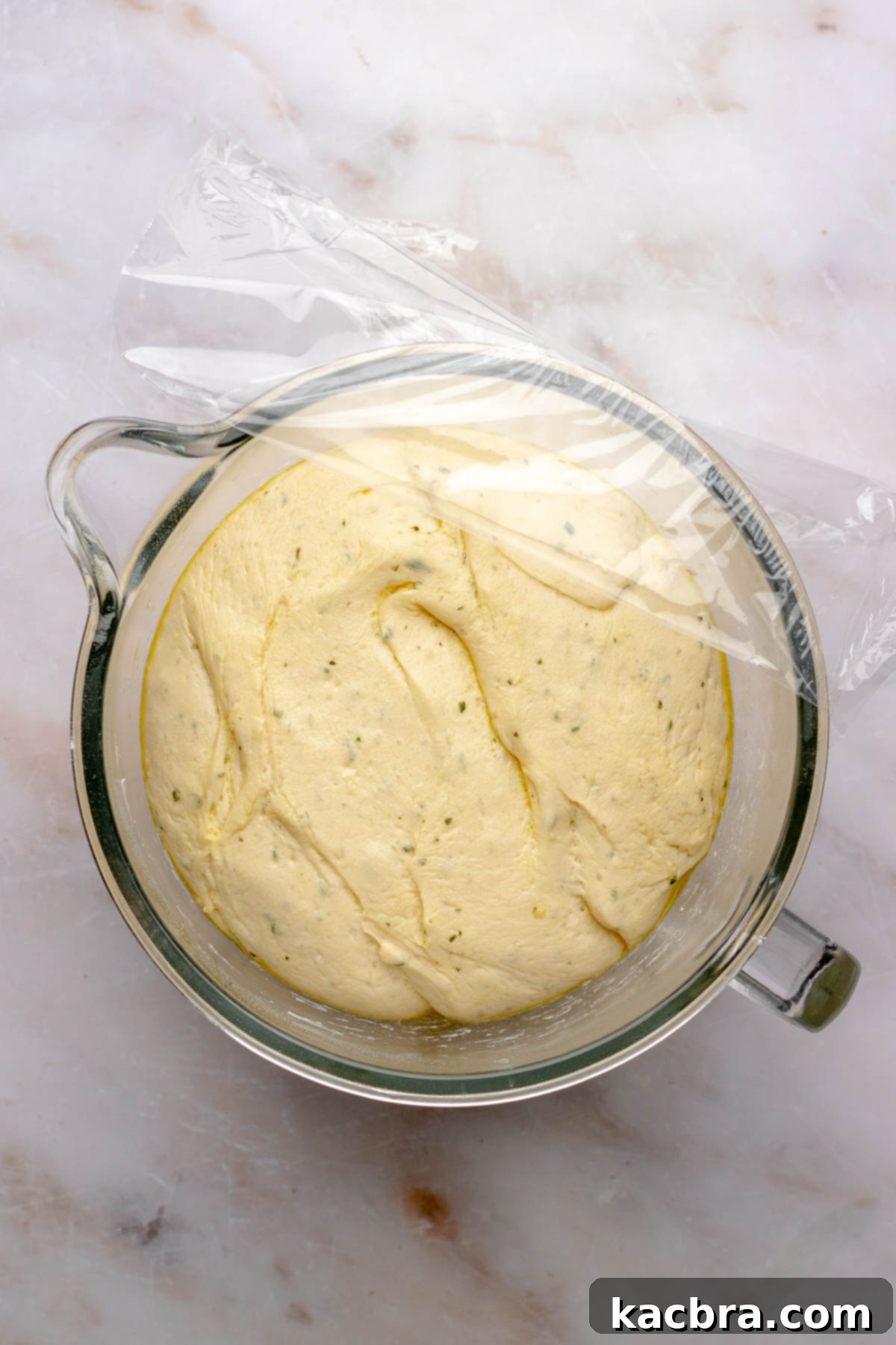 Fluffy Savory Rolls with Golden Hollandaise 10 Risen herb dough in a bowl, showing it has doubled in size.