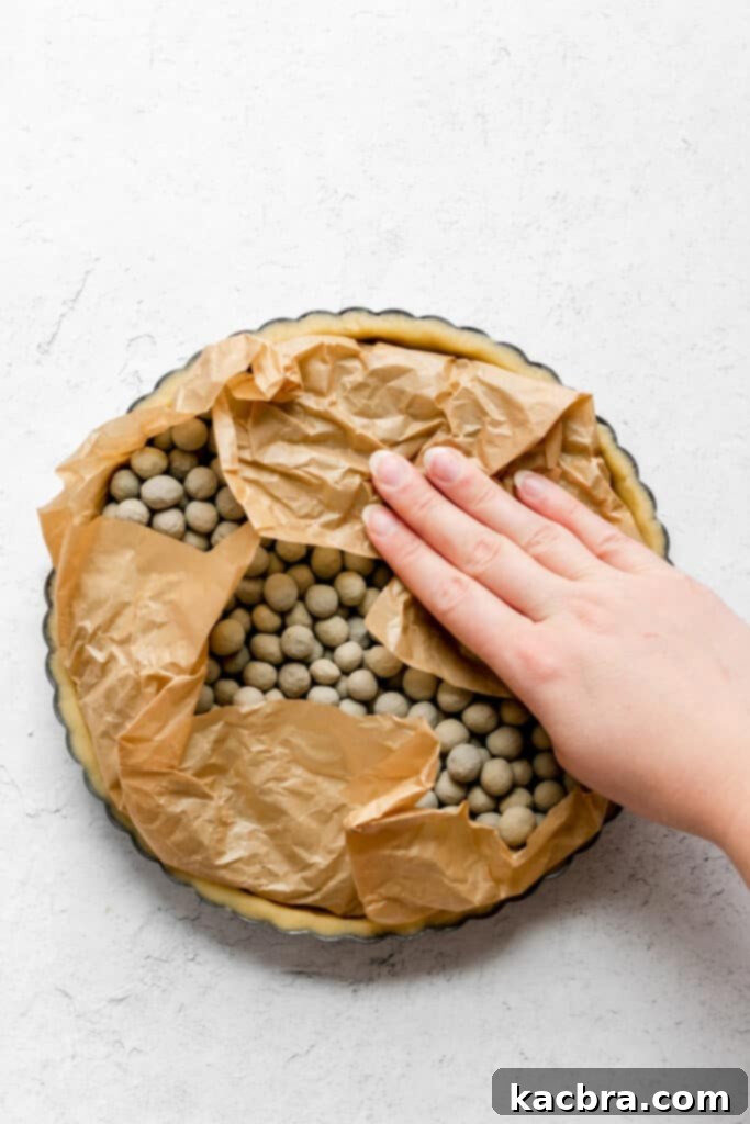 Tart shell filled with pie weights for blind baking
