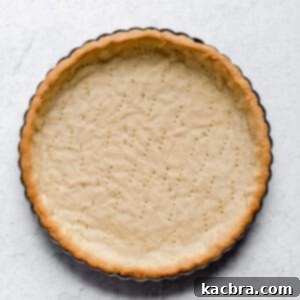 Fully baked sweet tart crust in a tart pan, ready to be filled.